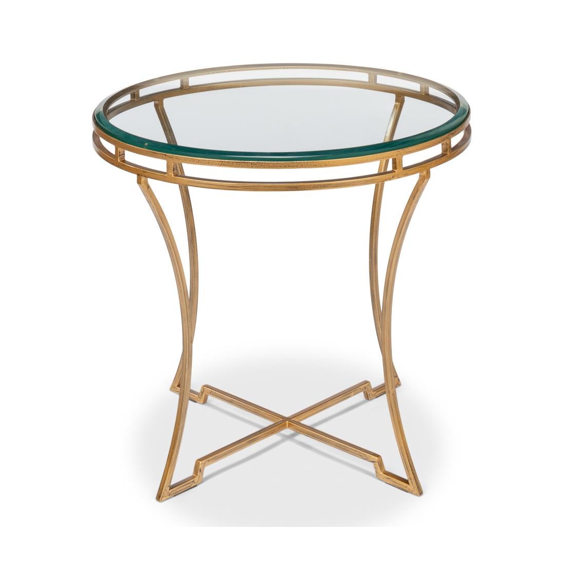 This piece stands out with its minimalist design, elevated by a warm, gold finish that exudes elegance and exclusivity. The table features a round, clear glass top, perfectly complementing the openwork gilded iron frame beneath.

With inswept