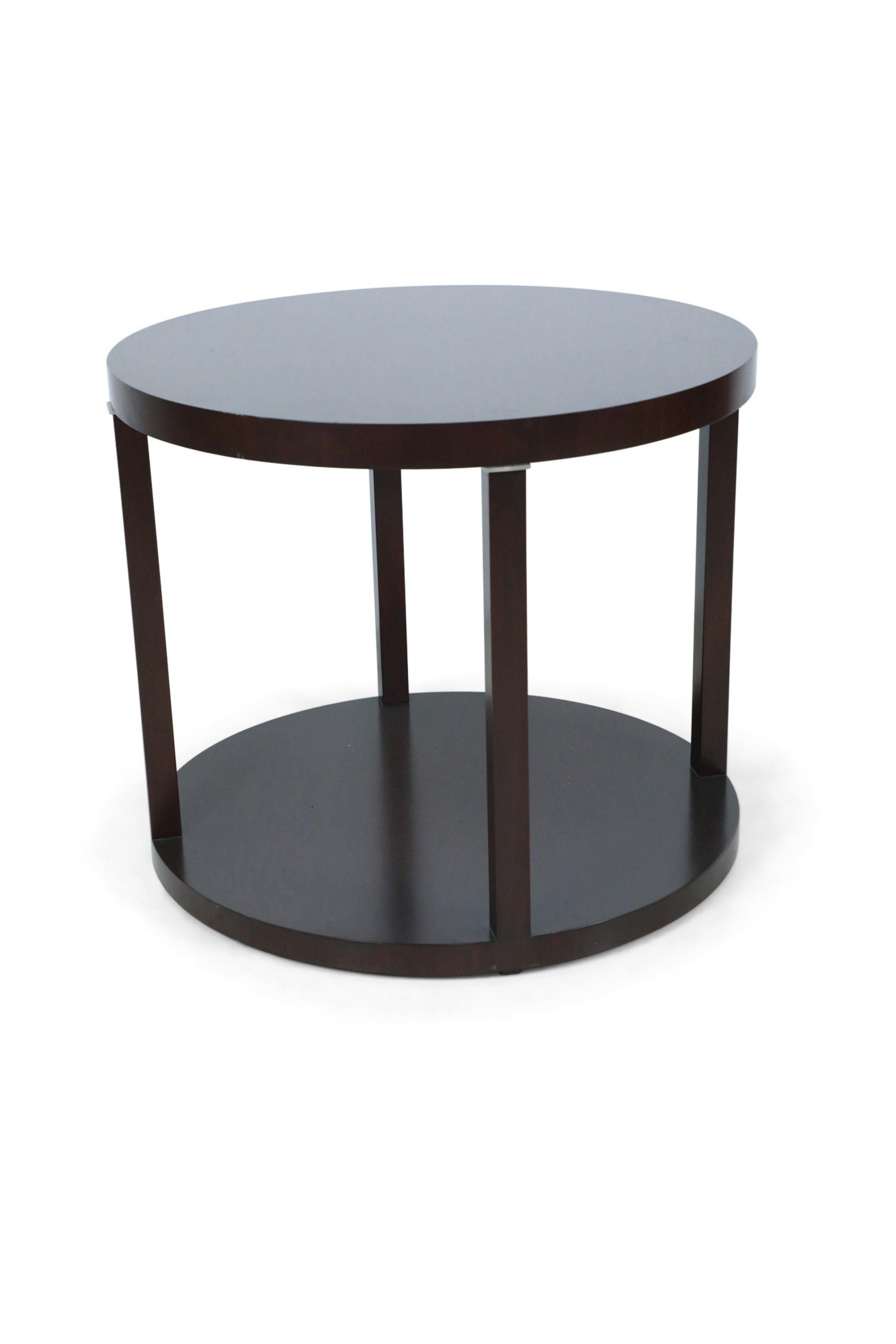 Contemporary round mahogany center table with four cylindrical legs atop a round platform base, with stainless steel detail at tops of columns.