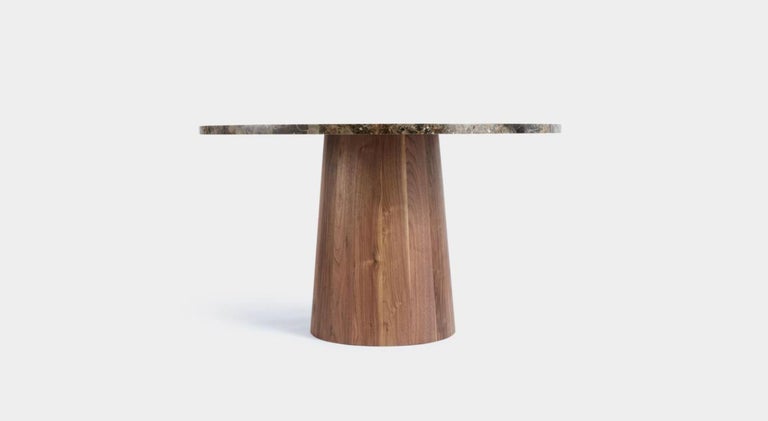 This handmade round pedestal table features a Dark Emperador marble top and solid walnut coopered base. Edward Collinson hand selects all their wood from English suppliers, the simplicity of the design is typical of Edwards work. Each base is made