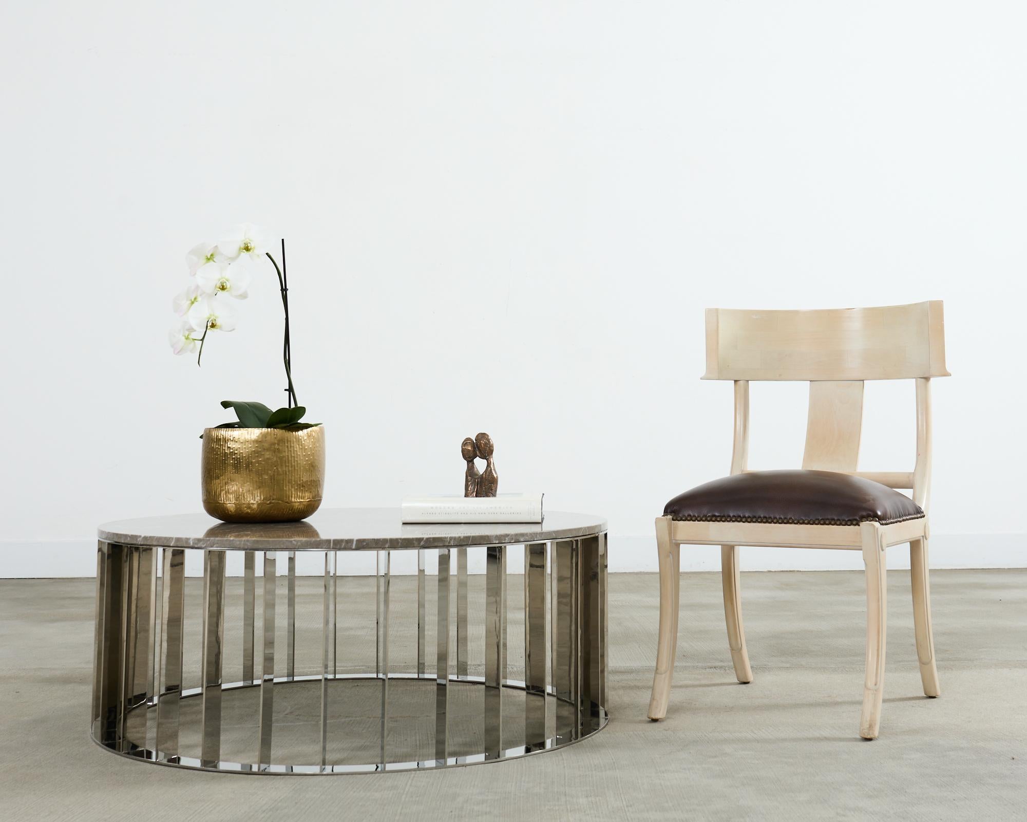 Elegante e unico tavolino da cocktail o da caffè moderno con piano in marmo e base a ventaglio. La base è realizzata in acciaio lucidato con una finitura cromata a specchio. La base è formata da un pezzo sagomato di marmo italiano spesso e pesante