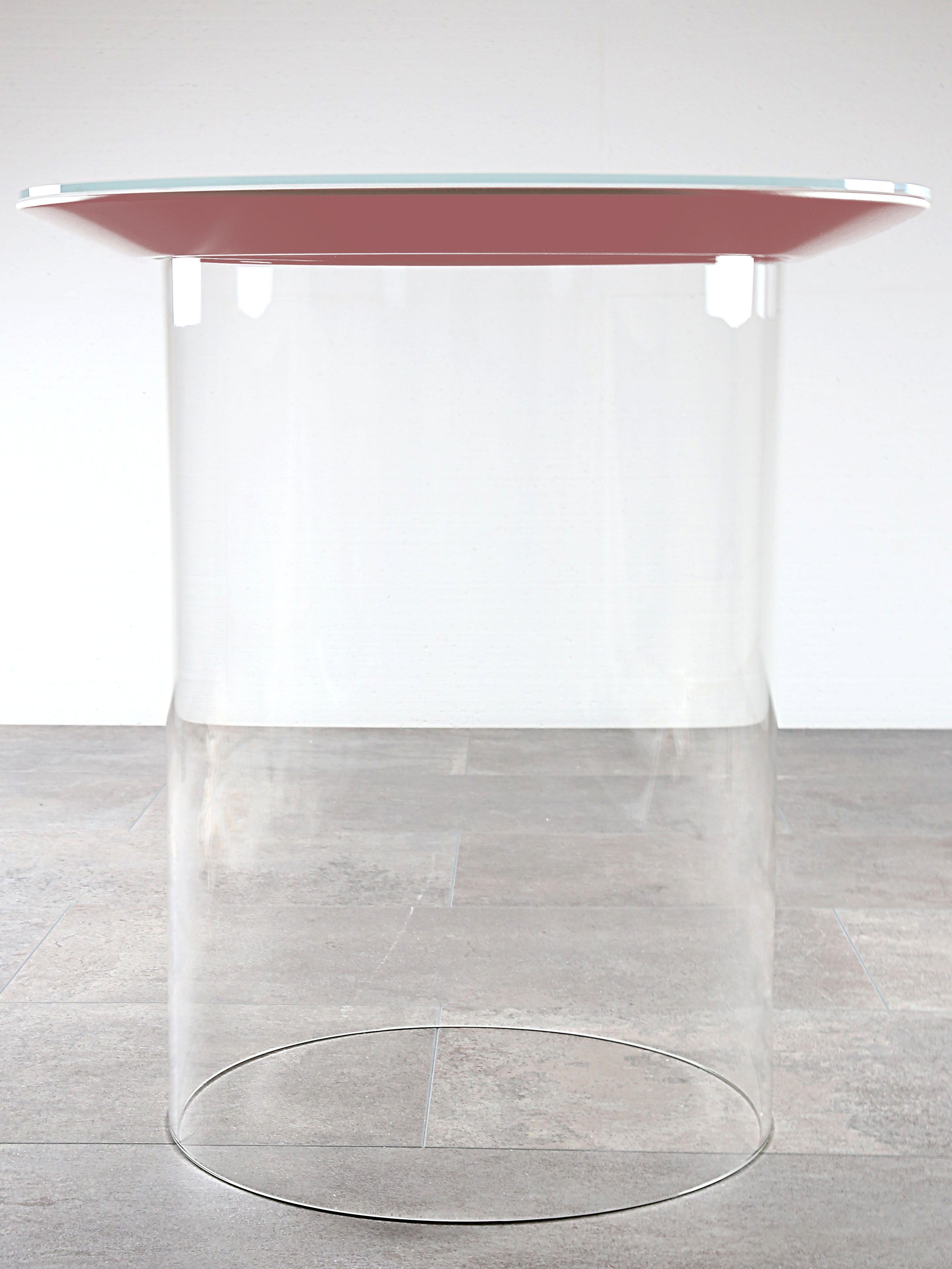 Award-winning side table dontCme is made of borosilicate glass, solid colored glass and lacquered MDF. 

The main topic of this work was to disguise the static necessities of furniture. As a result, carried by a glass cylinder, the round frame