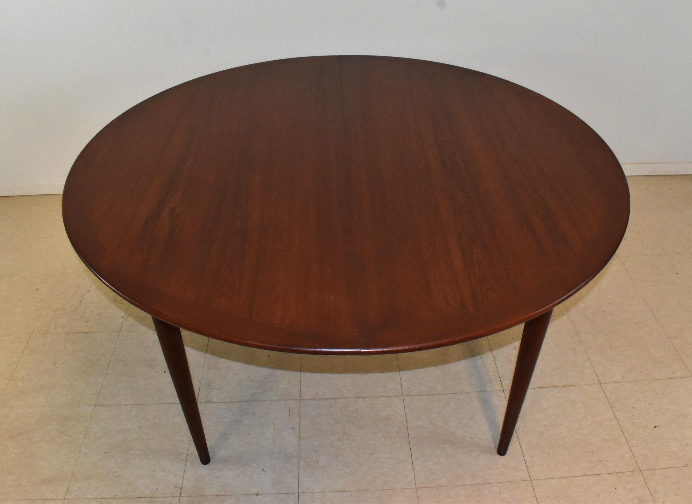 Mid-Century Modern round teak table by Grete Jalk for P. Jeppesens-Mobelfabrik. Tapered legs and two skirted 21