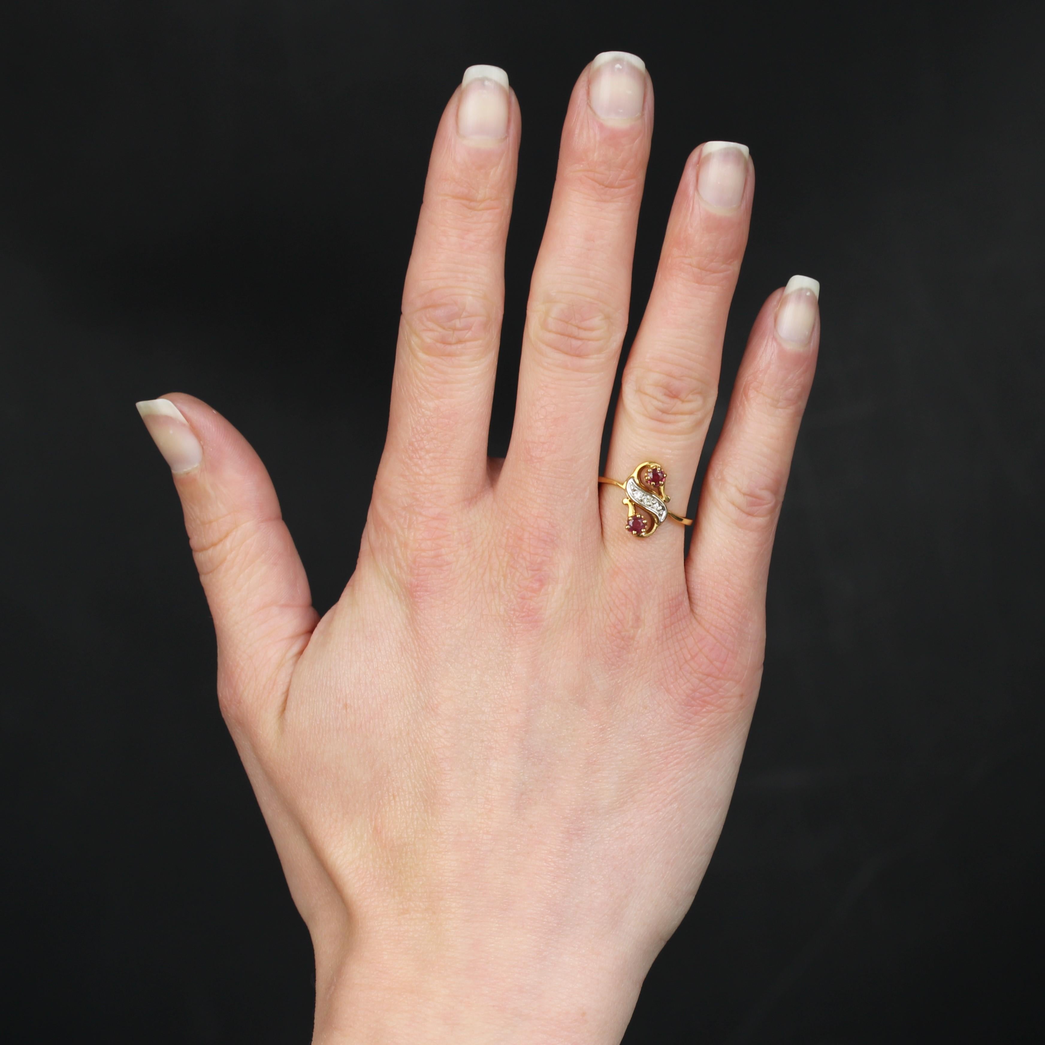 Ring aus 18 Karat Gelbgold, Adlerkopfpunze.
Er formt ein arabeskes Muster mit 2 runden Rubinen in Krallenfassung und ein mit 3 Brillanten besetztes Wellenmuster aus Weißgold.
Gewicht des Rubins: ca. 0,28 Karat.
Höhe: ca. 14 mm, Breite: ca. 9,5 mm,