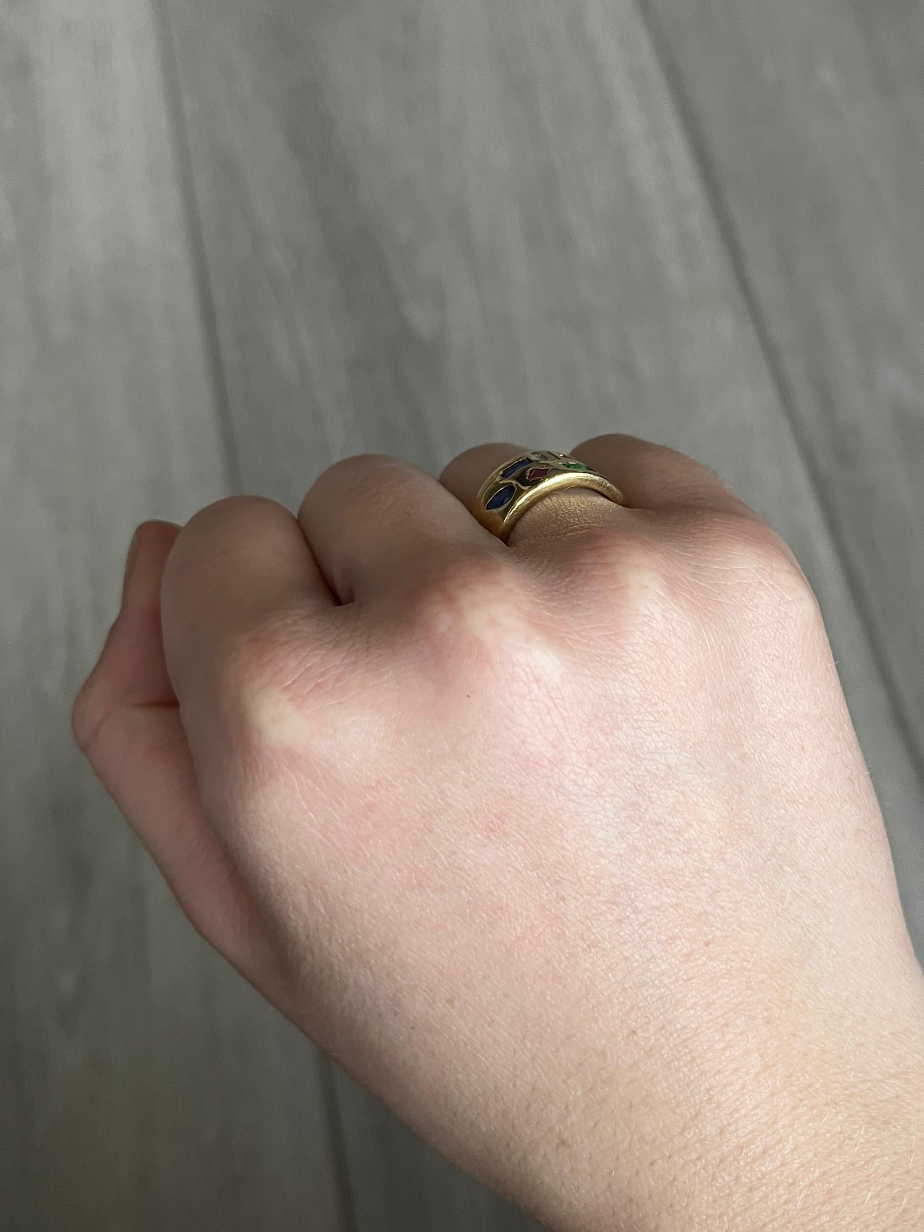 Dieses glänzende 15-karätige Goldband enthält einen Rubin, einen Amethysten, einen Saphir, einen Smaragd und einen Diamanten, die in butterweiches Gold eingefasst sind. 

Ringgröße: K 1/2 oder 5 1/2 
Breite des Bandes: 10,5 mm

Gewicht: 5g