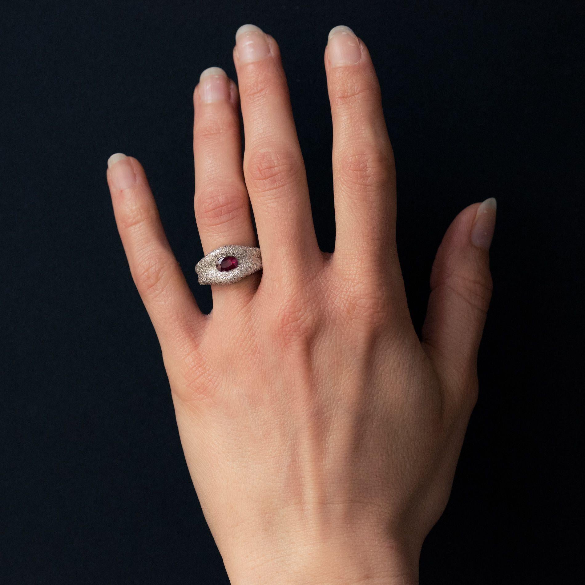 Ring in 18 karats white gold, eagle head hallmark.
White gold modern ring featuring a bezel set oval ruby in a pave diamond bed. This refined and striking ring has a double band and the ruby glints delightfully among the smaller glistening