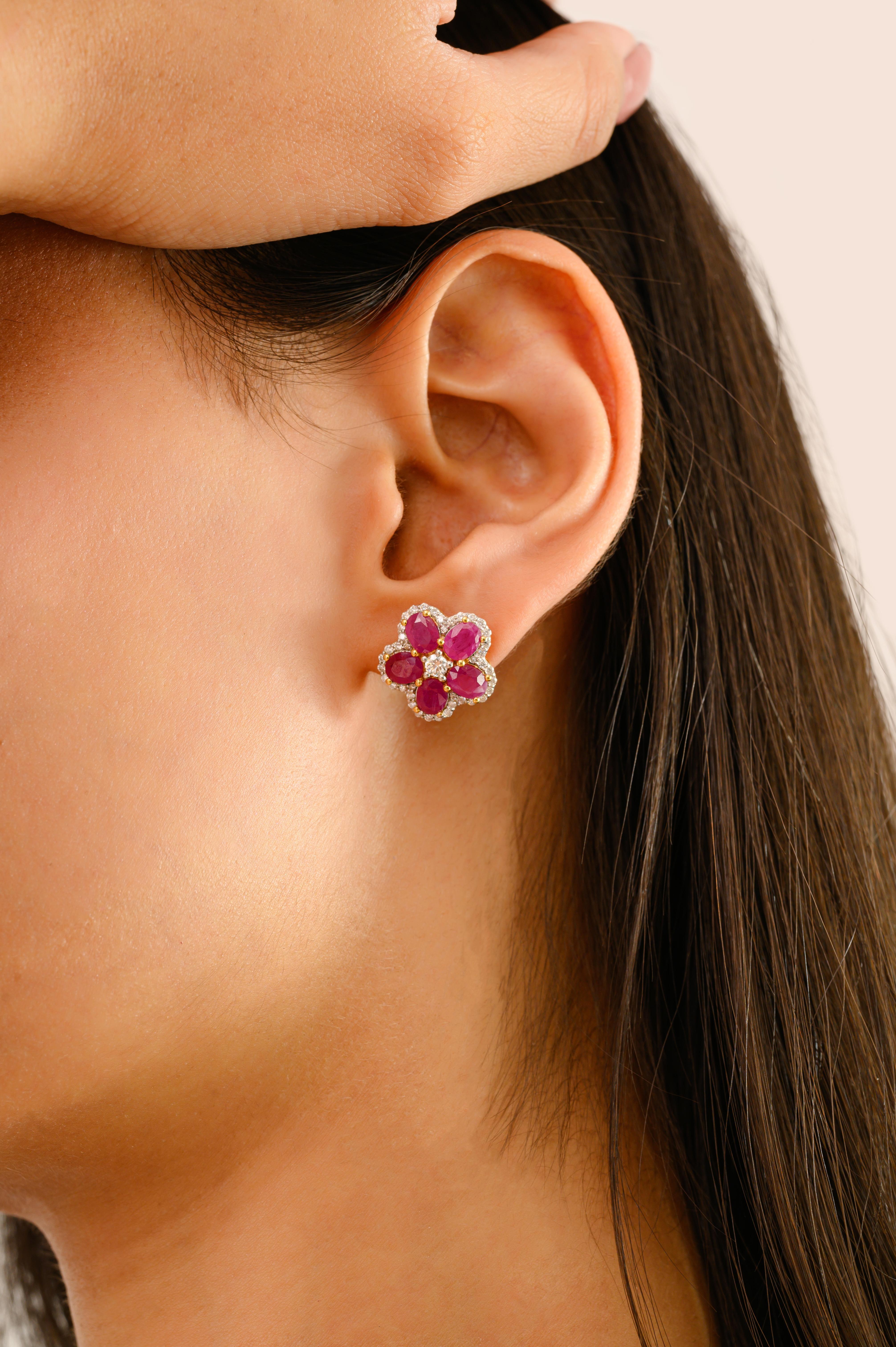 Irradiando encanto y color vibrante, estos exquisitos pendientes florales están meticulosamente elaborados en oro amarillo de 14k. Cada pendiente presenta un asombroso motivo floral compuesto por cinco rubíes talla oval de ricos matices que suman un