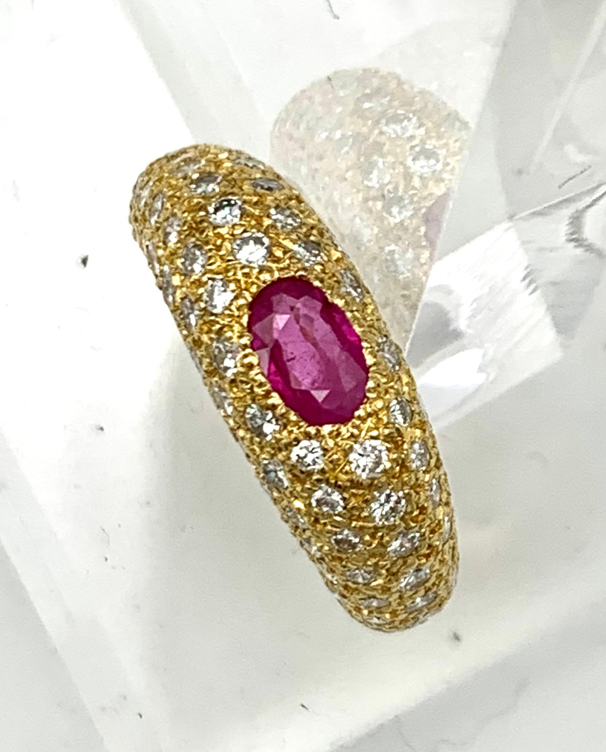 This solid domed ring was made by the London based jeweller T.O'Donoghue. It is stamped with the makers initials TO'D, the London hallmark for 18 karat and the year letter O for 1988. The ring is set with an oval ruby and 76 brilliant cut round