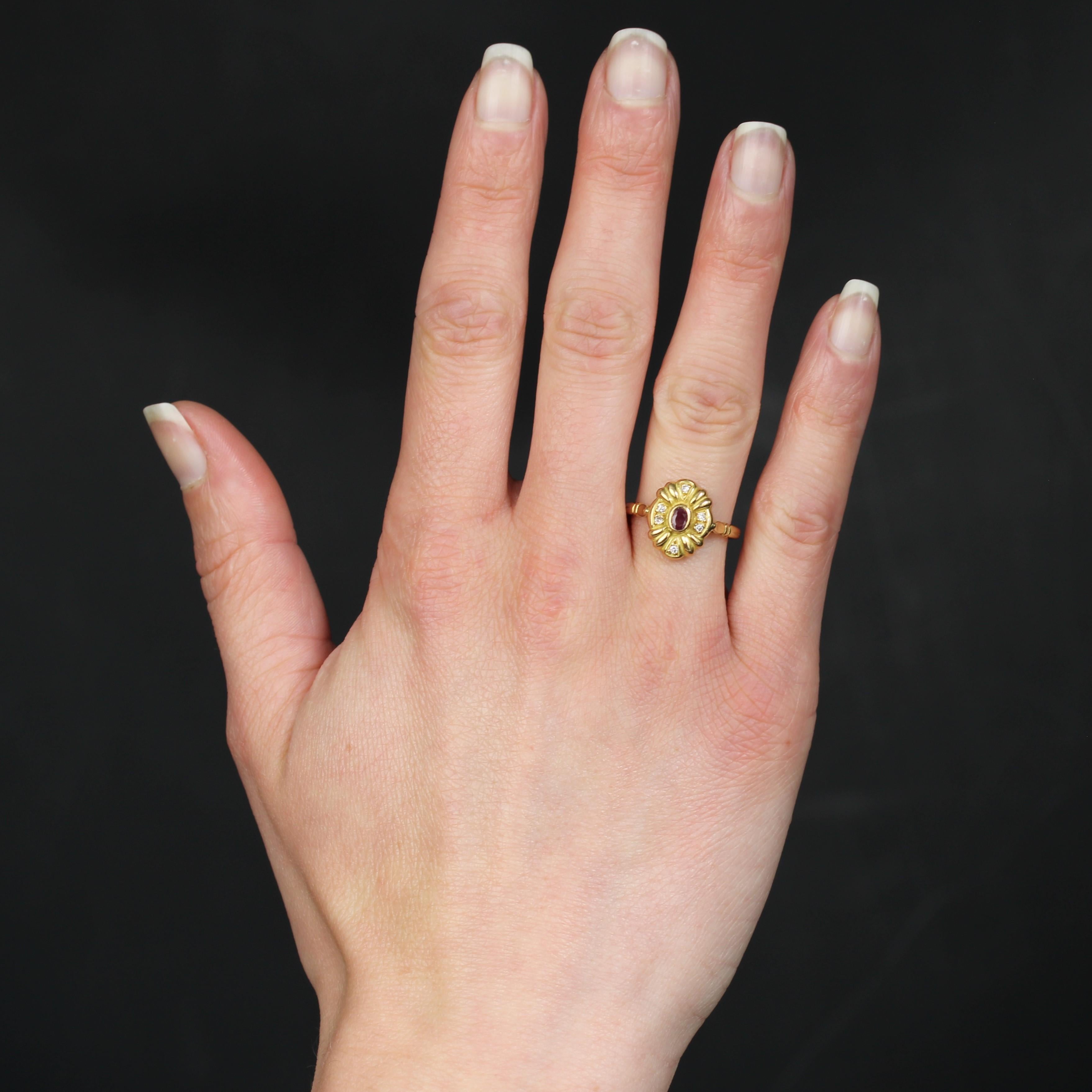 Ring in 18 karat yellow gold.
This second hand ring is set with an oval ruby in closed setting, surrounded by gadroons alternating on each side with 2x2 diamonds and from top to bottom with 1x2 diamonds. The profile is openworked with triangular