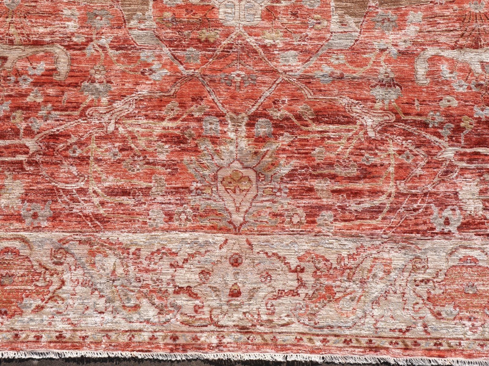 A beautiful 8 x 10 ft contemporary rug hand knotted wool and real mulberry silk pile. On a pinkish coral red field, the design of traditional Oushak and Heriz elements standing next to each other executed in beiges, browns and copper tones.
Design