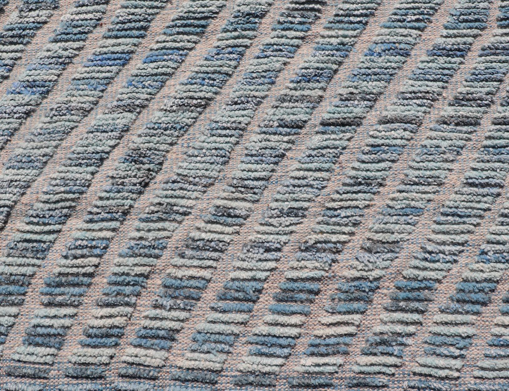 Moderno Tappeto moderno in lana con disegno a strisce sub-geometriche in blu, con alti e bassi. in vendita