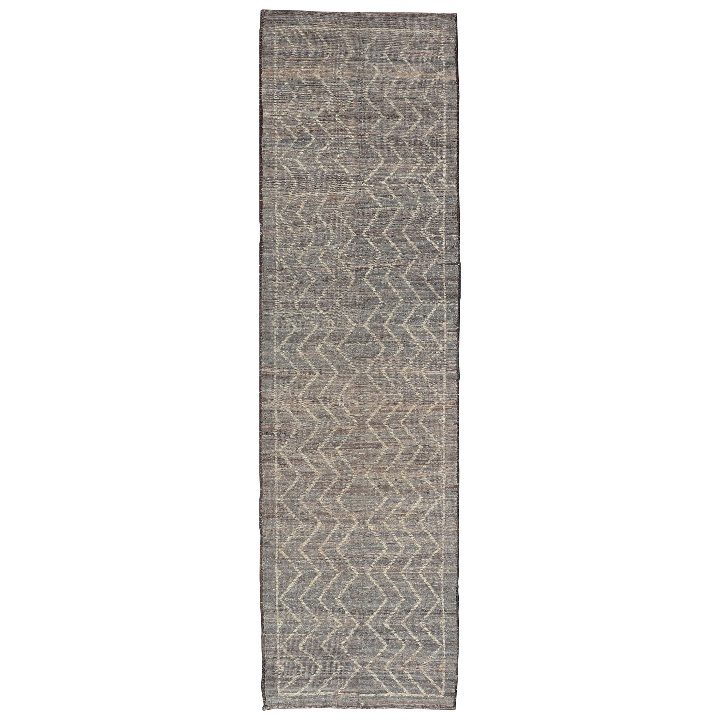 Alfombra moderna con diseño tribal en colores gris claro, topo, crema y natural