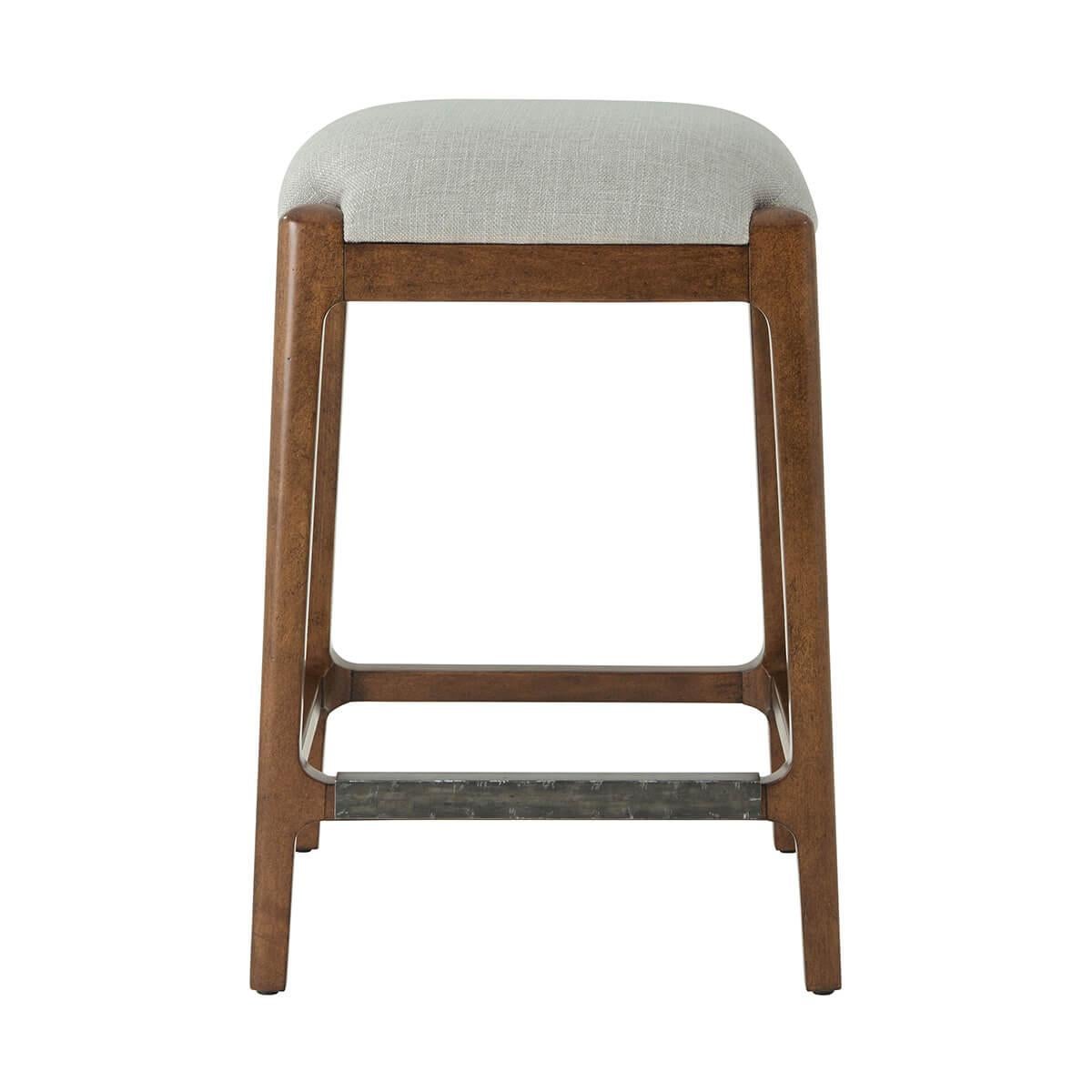 with an upholstered cushion seat covered in performance fabric, on splayed tapering legs joined by a stretcher in a slightly distressed warm color finish.

Dimensions: 17.75