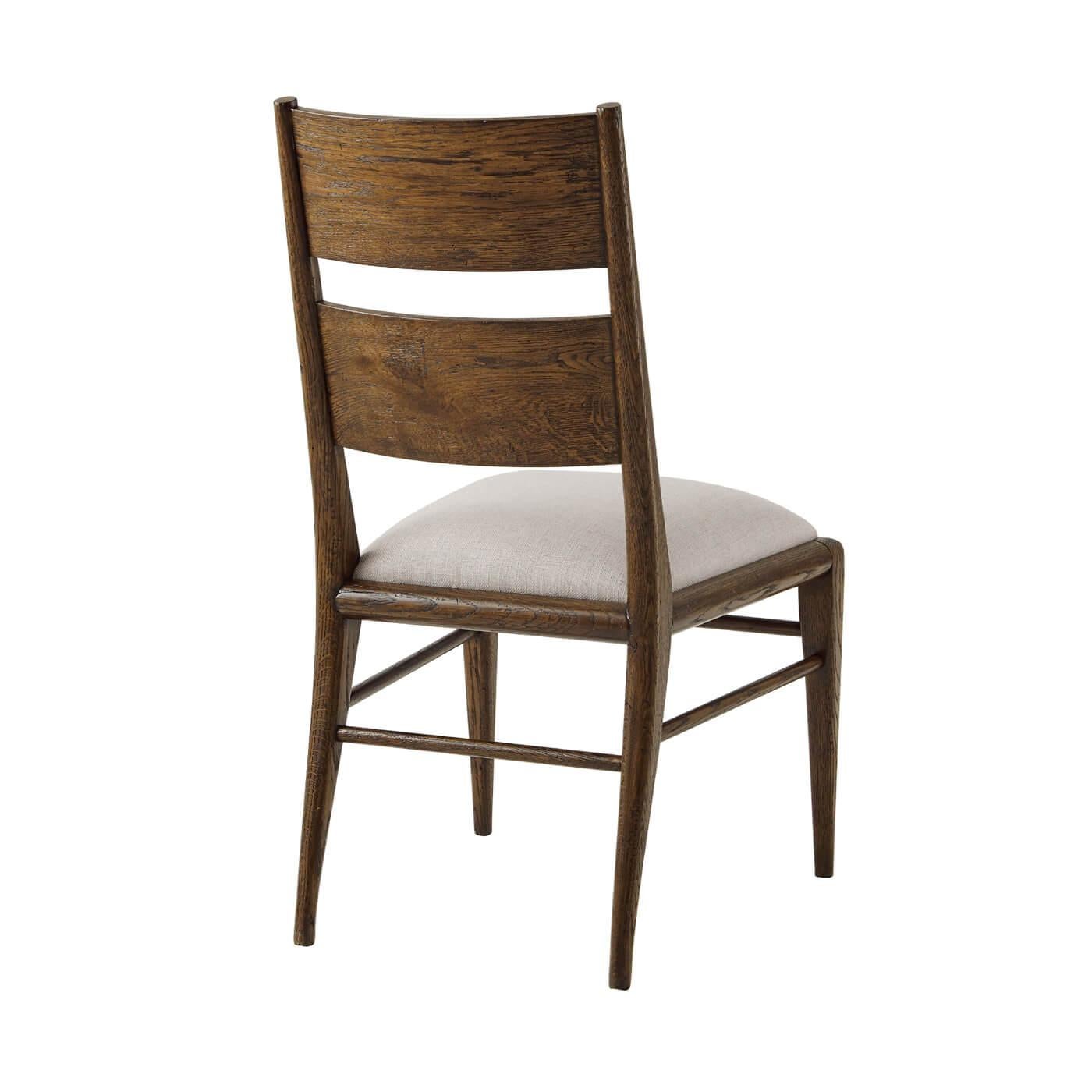 A dark oak parquetry dining chair with tapered oak legs. Its upholstered seat is constructed with a top and mid-rail bar joined by stretchers. 
Shown in Dusk Finish
Shown in Linen-UP5409 Fabric
Dimensions
19.5