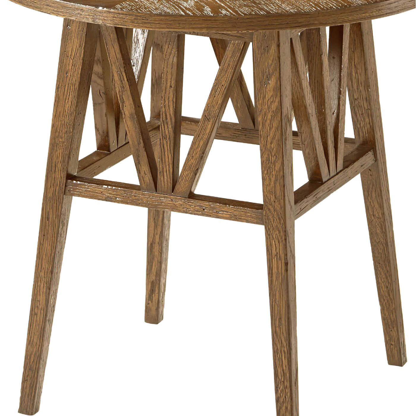 A light modern rustic oak round end table with a geometrically arranged oak pattern on the round top. It is crafted with a flat truss oak stretcher and tapered oak leg. 
Dawn finish
Dimensions
22