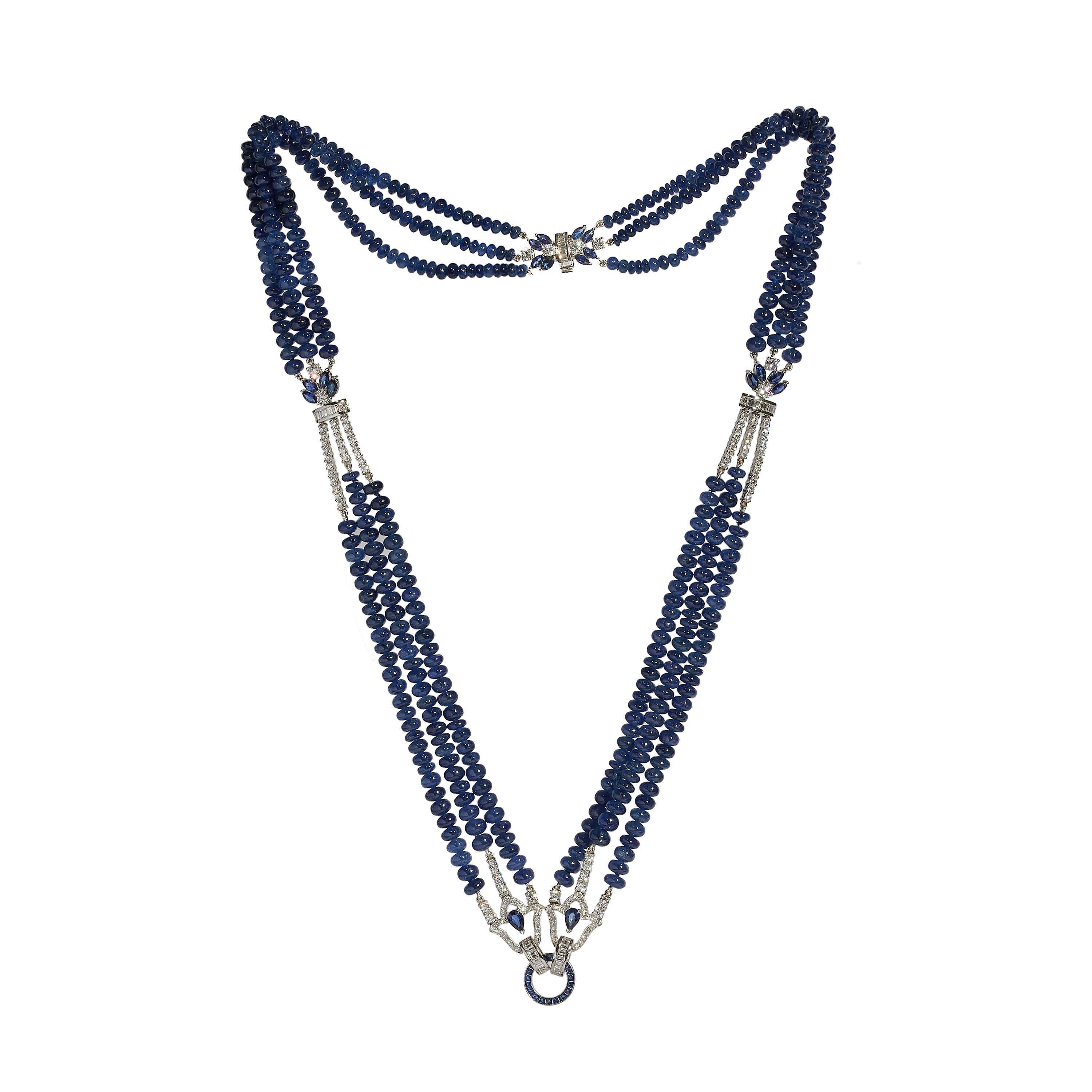 A modern sapphire, diamond and platinum tassel pendant necklace, consisting of a three row cabochon sapphire bead necklace, with marquise sapphire and baguette and round brilliant-cut diamond set dividers and clasp, and pear shape sapphire and