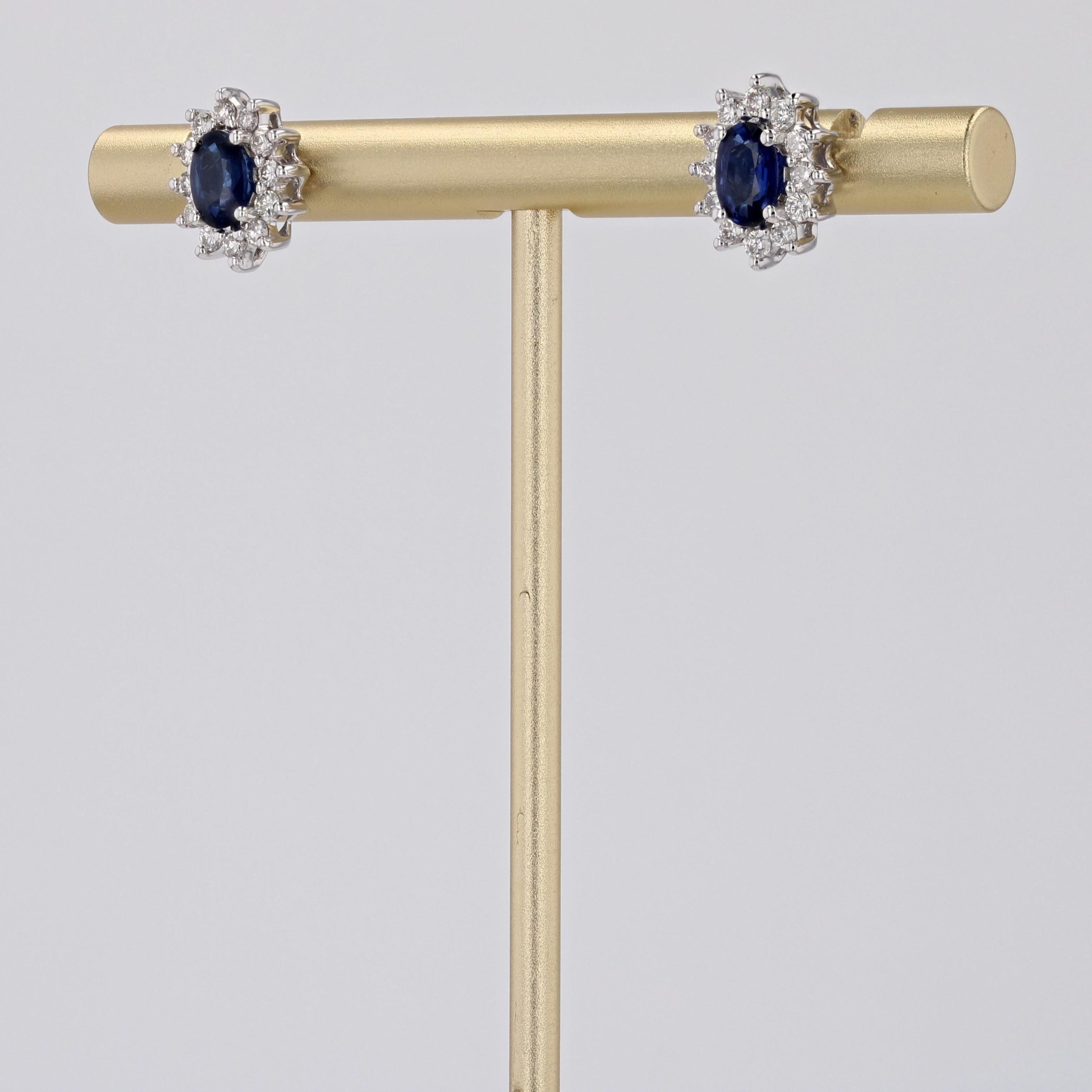 Für gepiercte Ohren.
Ohrringe aus 18 Karat Weißgold.
Diese Gänseblümchen-Ohrringe haben in der Mitte einen ovalen blauen Saphir, der mit modernen Diamanten im Brillantschliff besetzt ist. Der Verschluss dieser Saphir-Diamant-Ohrringe ist ein