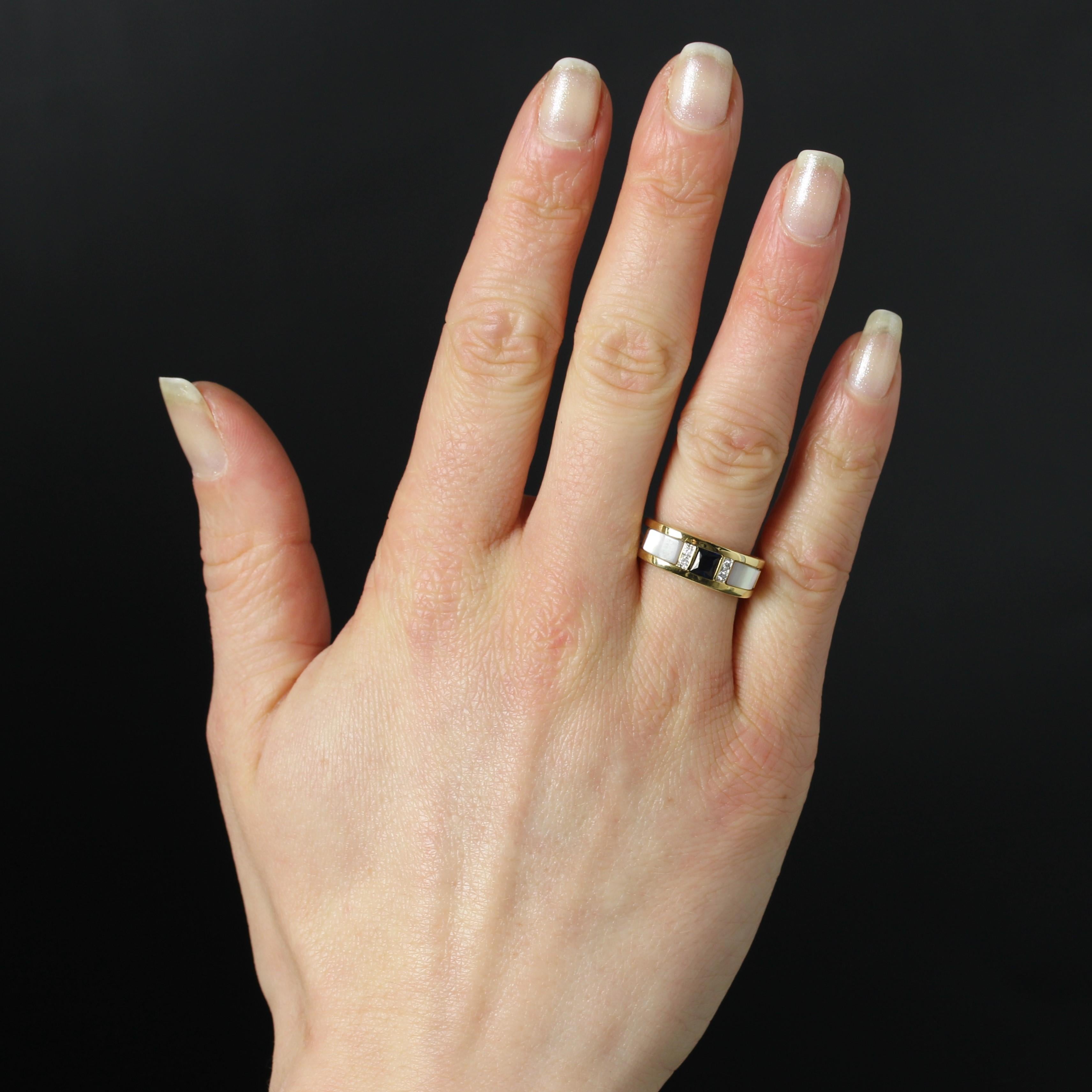 Ring in 18 karat yellow gold, eagle head hallmark.
The setting of this second-hand yellow gold ring is formed of 2 rings that are adorned on the front center with a square sapphire shouldered on either side with 2x2 modern brilliant-cut diamonds,