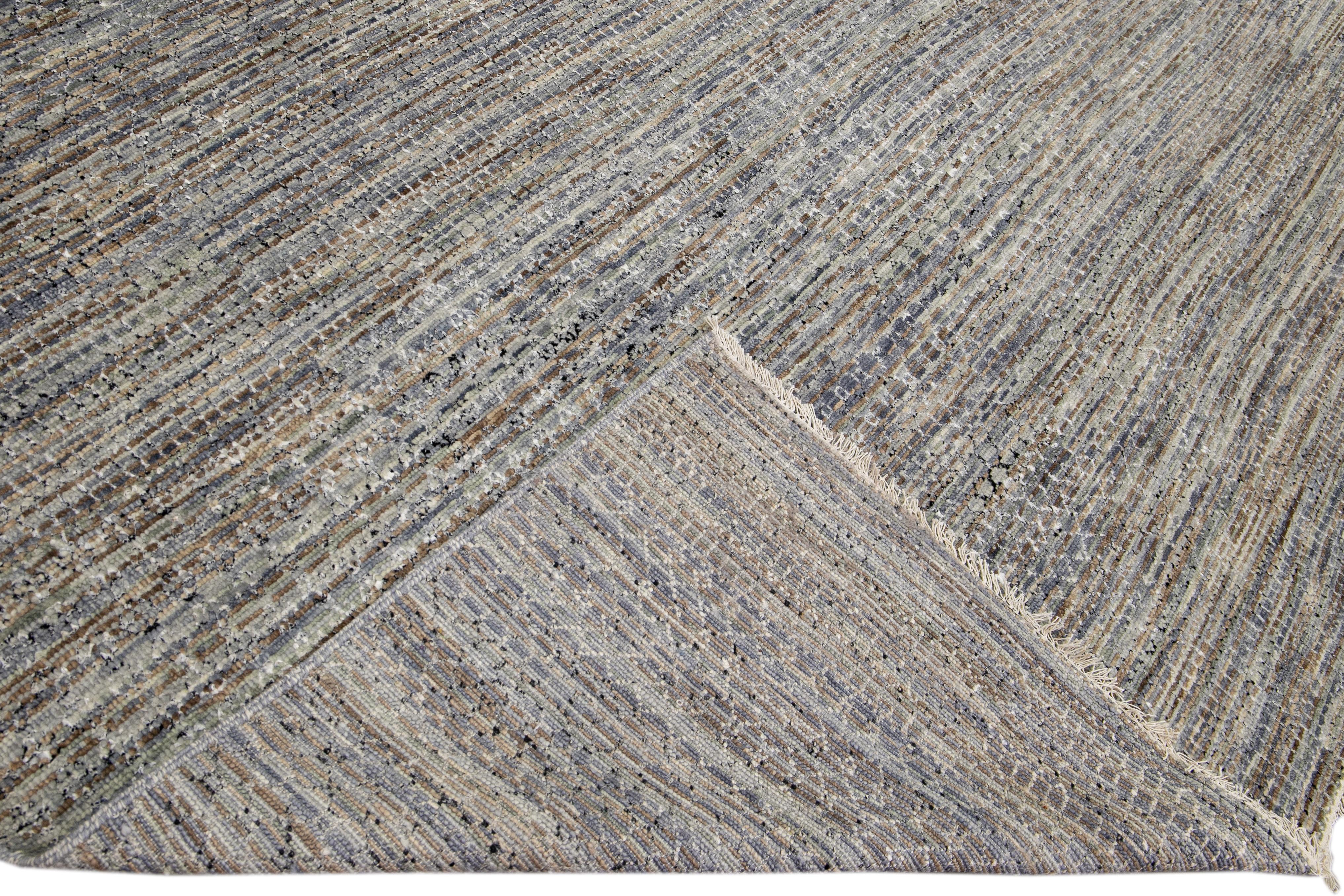 Bellissimo tappeto contemporaneo Savannah in lana annodato a mano con un campo grigio e beige finemente dettagliato in un disegno geometrico bianco all-over.

Questo tappeto misura: 13' x 19'10