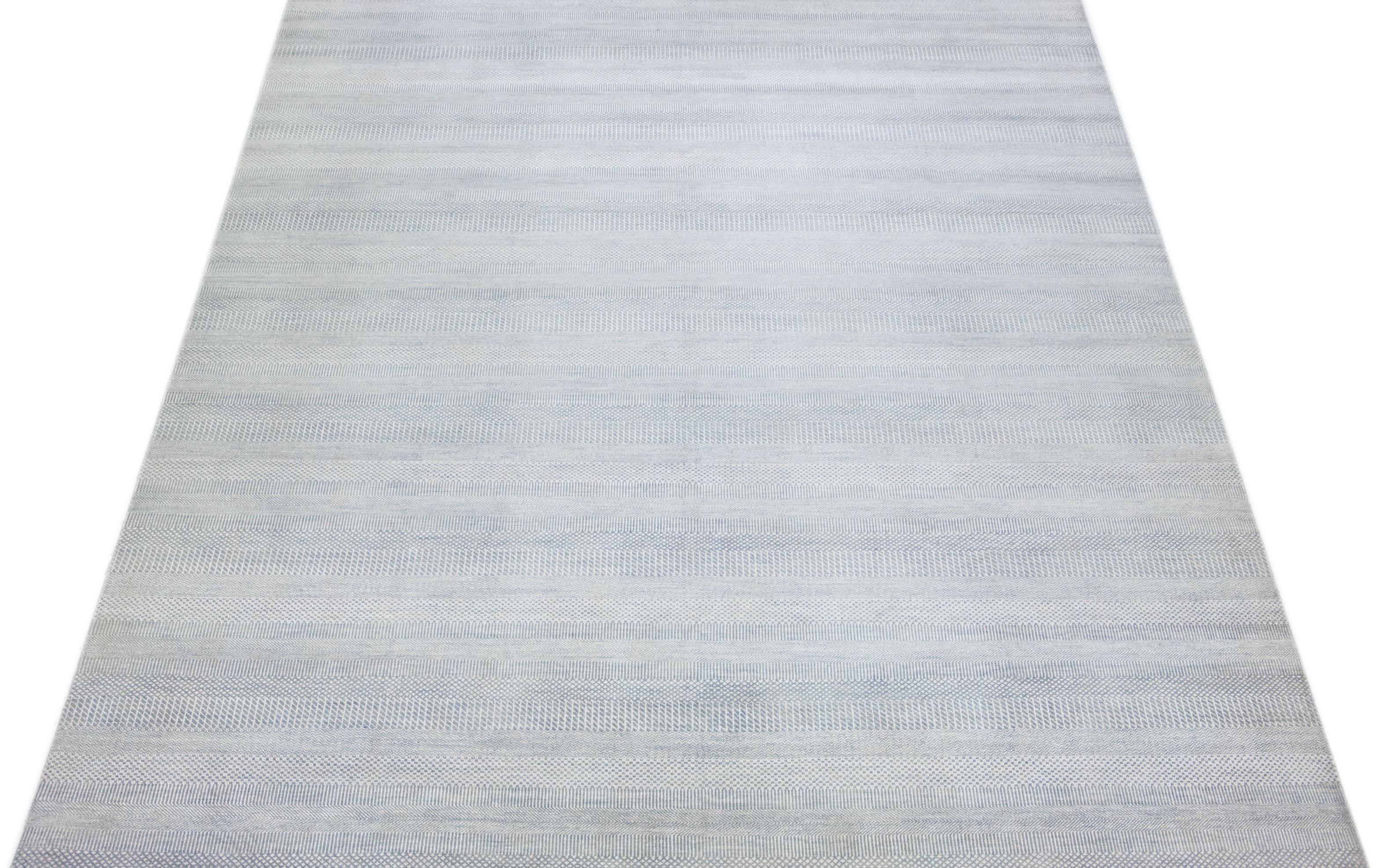 Dieser elegante, handgeknüpfte Teppich ist aus Wolle gefertigt. Es zeichnet sich durch ein dezentes hellblaues Farbschema aus, das durch ein geometrisches Allover-Muster akzentuiert wird - eine ideale Ergänzung für jede moderne