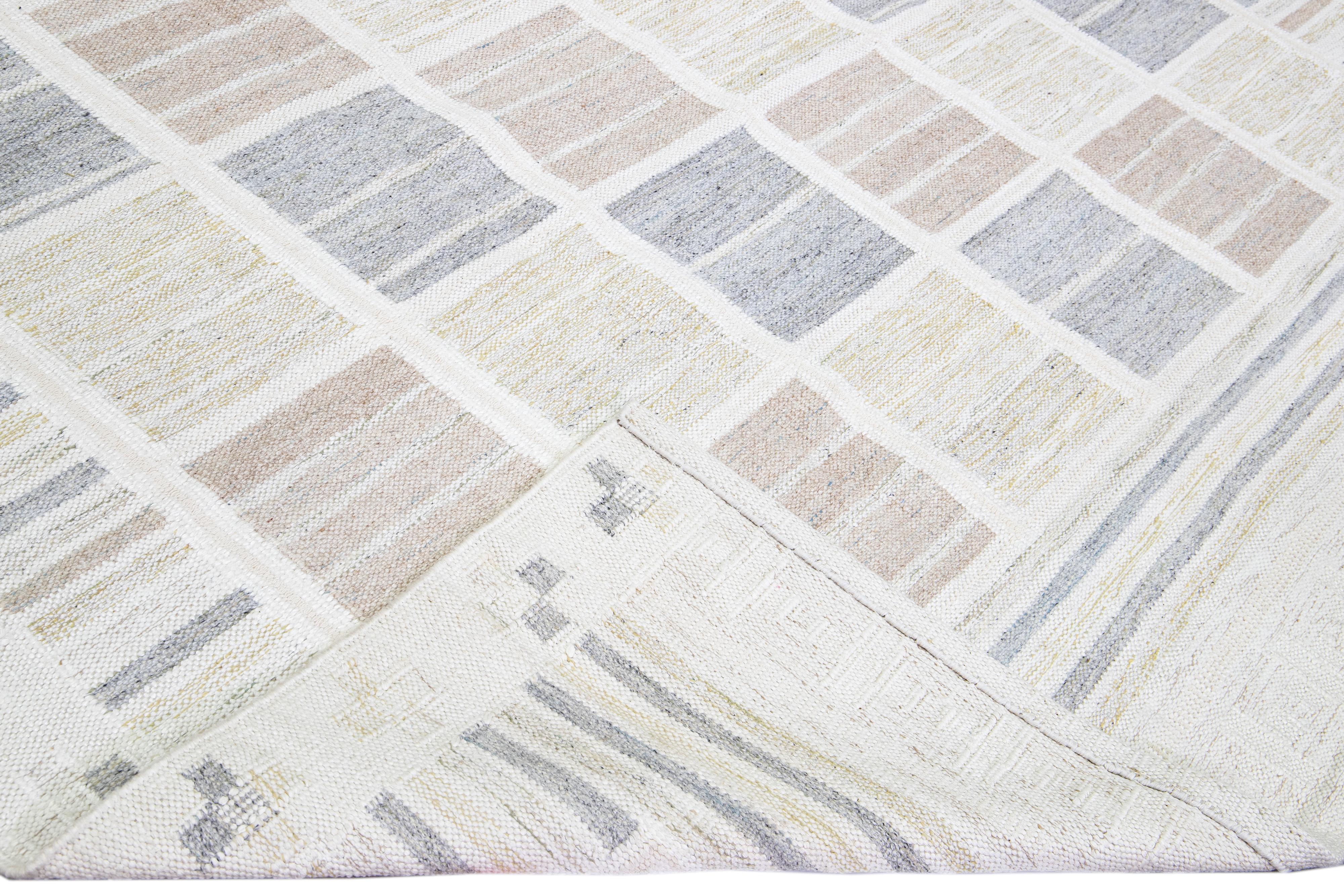 Beautiful Scandinavian style wool rug with a beige field. This modern rug has accents of blue, yellow, and cream beige in a gorgeous all-over geometric pattern design.

 This rug measures: 9'11
