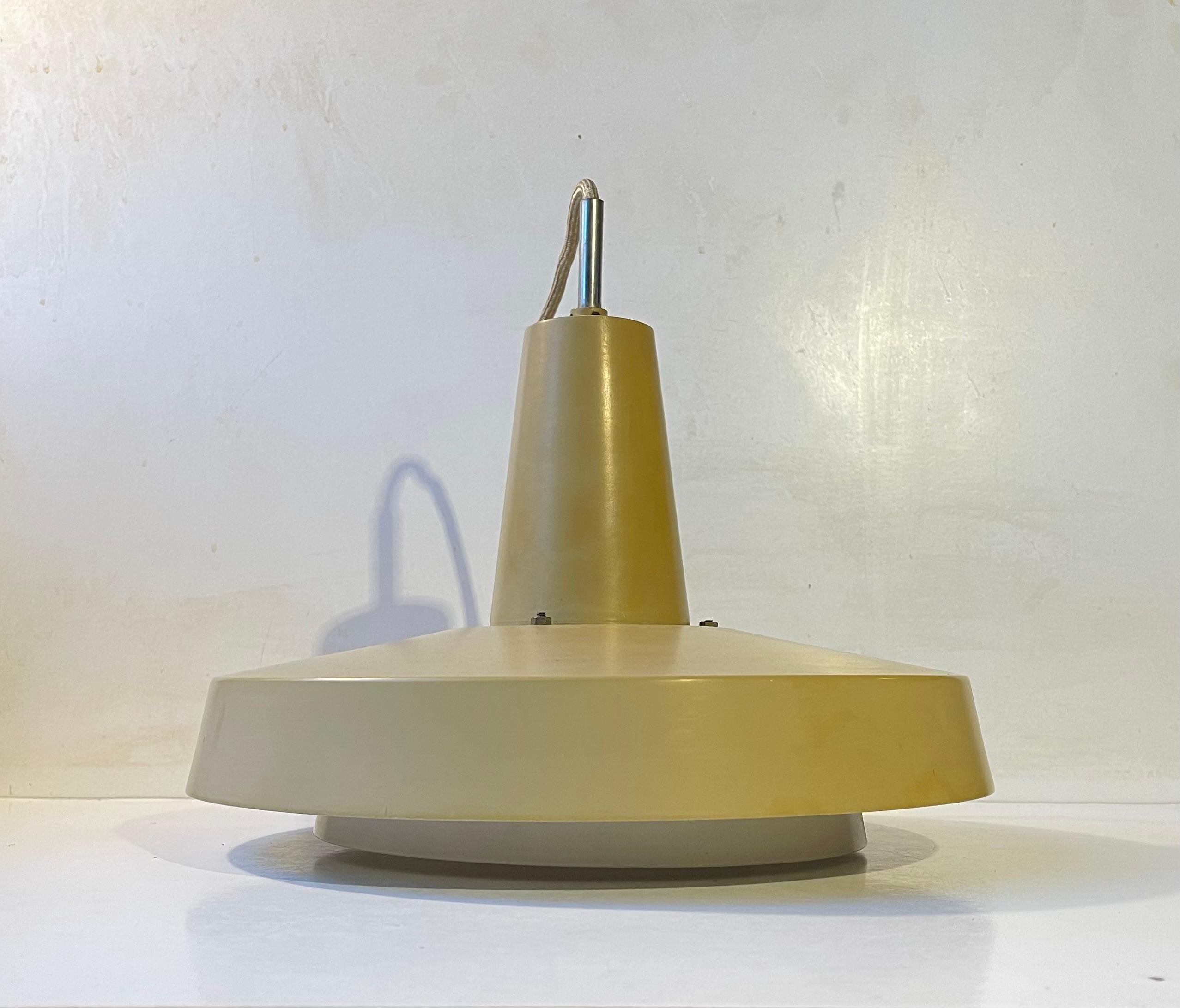 A rare pastel mustard yellow pendant light from Lyfa in Denmark. It is called 'Top' and was designed in 1967 by husband and wife Eva & Niels Koppel in collaboration with Erik Thyring and Gert Edstrand. It suitable for lighting in your entrance, over