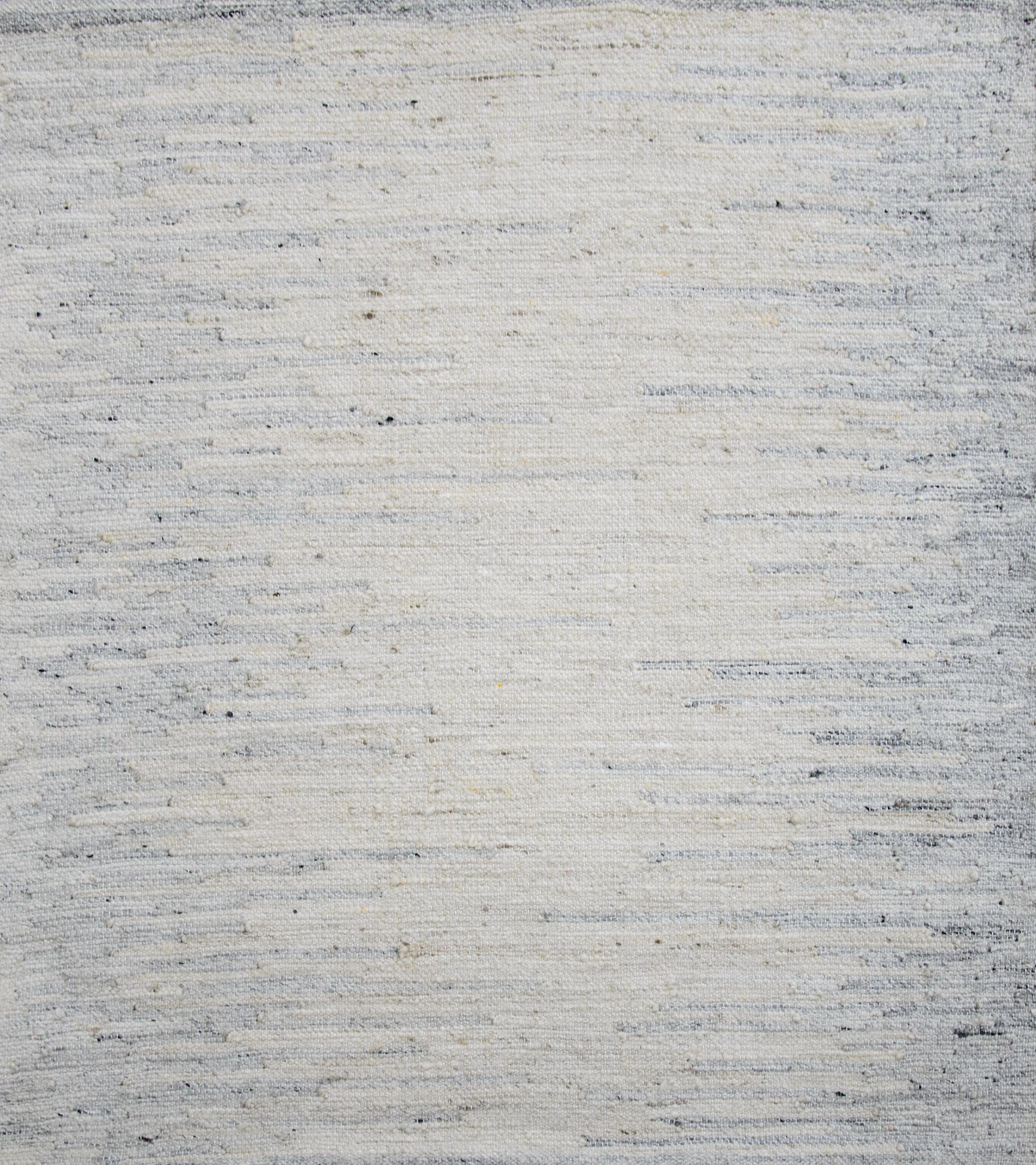 Moderner Flächenteppich im skandinavischen Design, handgewebt aus feiner Wolle und organischen Farbstoffen. Es zeichnet sich durch ein exquisites elfenbeinfarbenes Feld mit grauen 