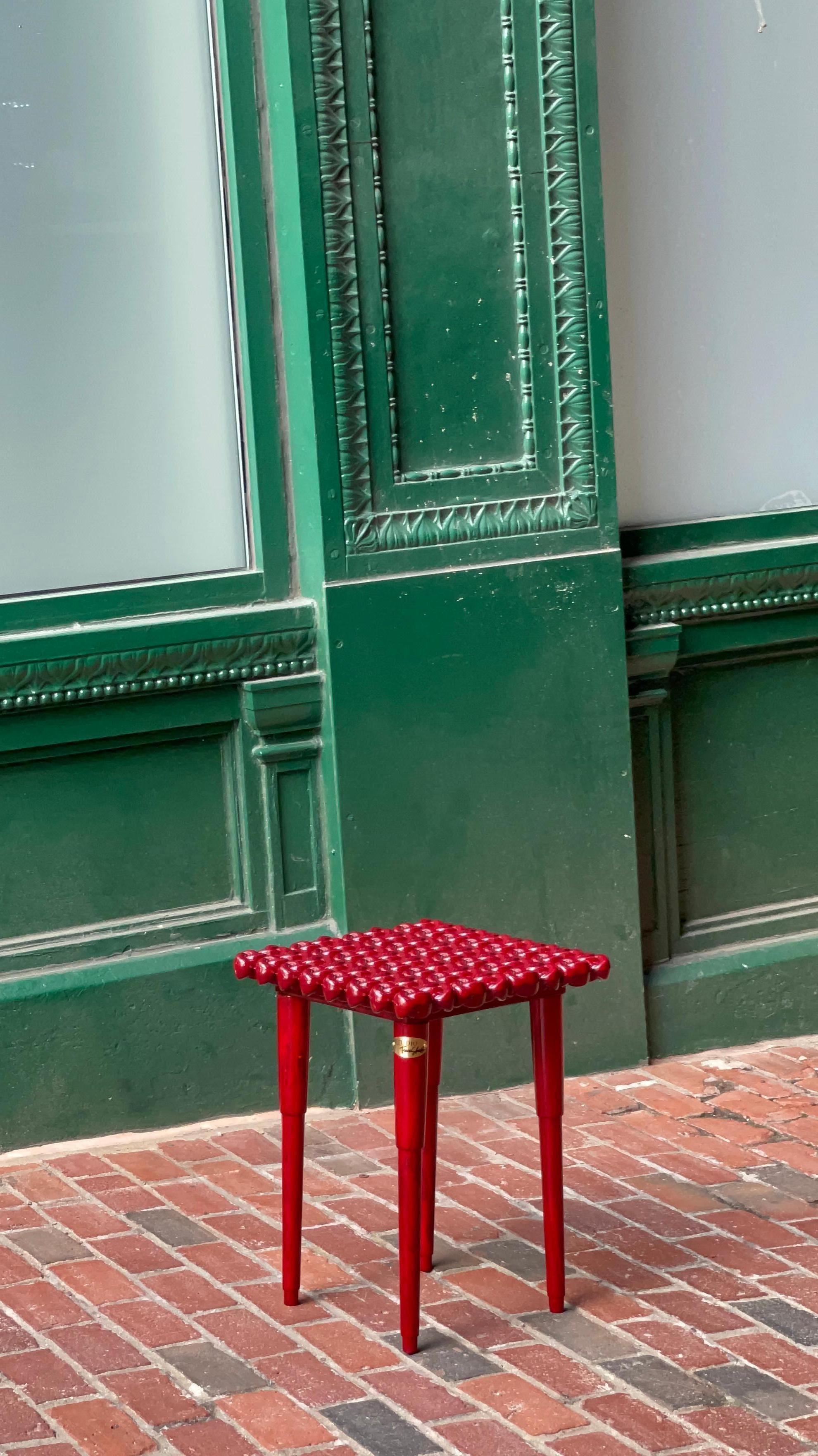This bold burgundy accent table adds a vibrant, stylish touch to modern, mid-century modern, eclectic, and industrial decor styles. Crafted in a rich, deep burgundy red with a unique sculptural wrap-around design, this compact round side table