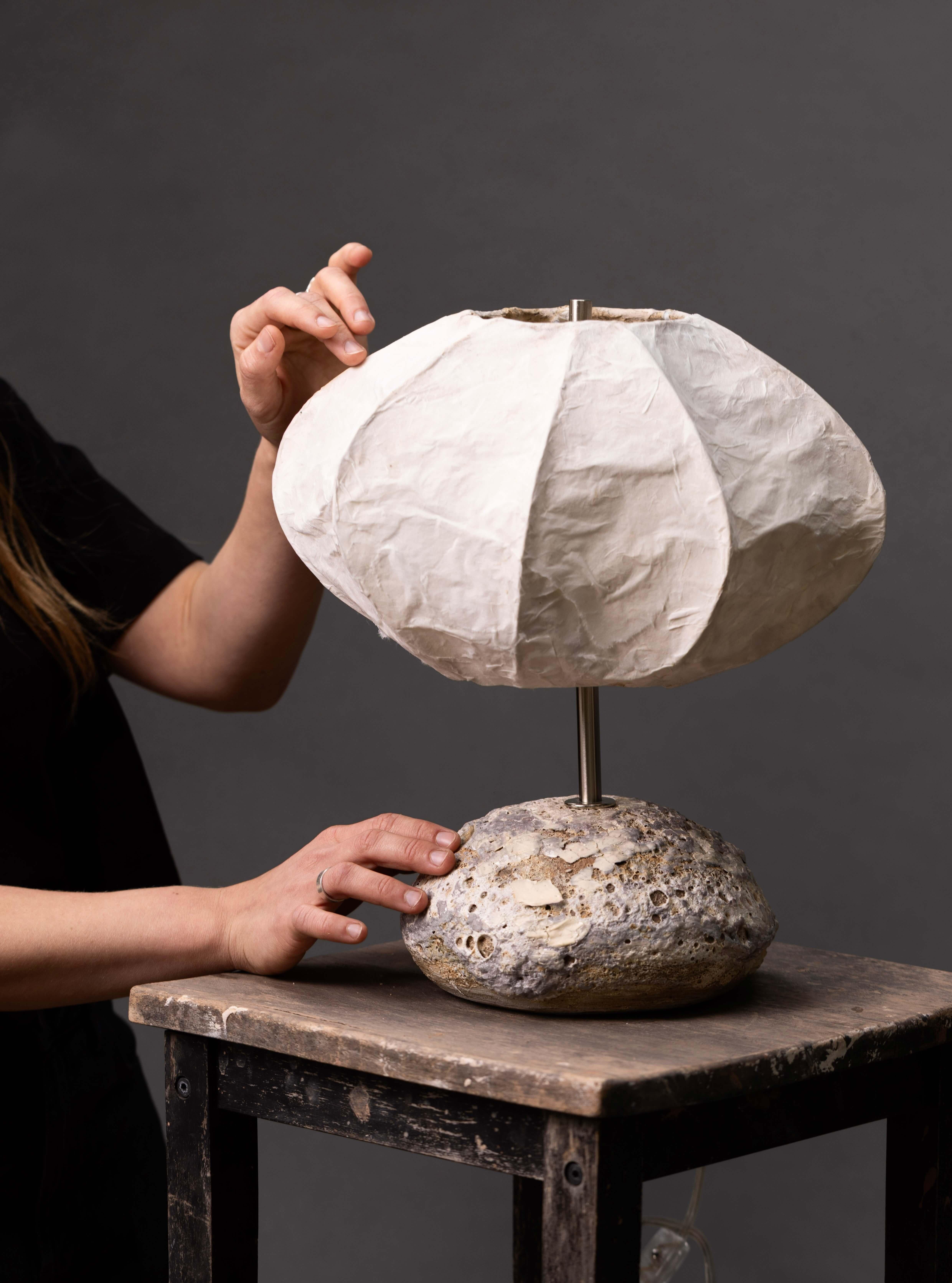 Diese Leuchte ist mehr als nur eine Lichtquelle, sie ist ein Statement - hier treffen natürliche MATERIALIEN auf zeitloses, skulpturales Design. Der mit Sorgfalt geformte und glasierte Keramiksockel verleiht Ihrem Raum einen erdigen Charakter und