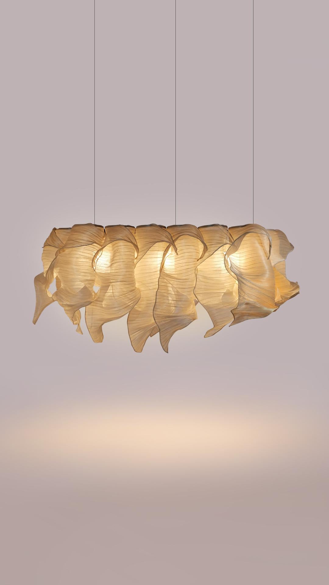 Providing soft light in an organic and unique design, the Nebula Pendant Chandelier draws its inspiration from the interstellar clouds of dust and gas. Entirely handcrafted of Banaca (banana-abaca), a fiber from the Philippines woven by a community