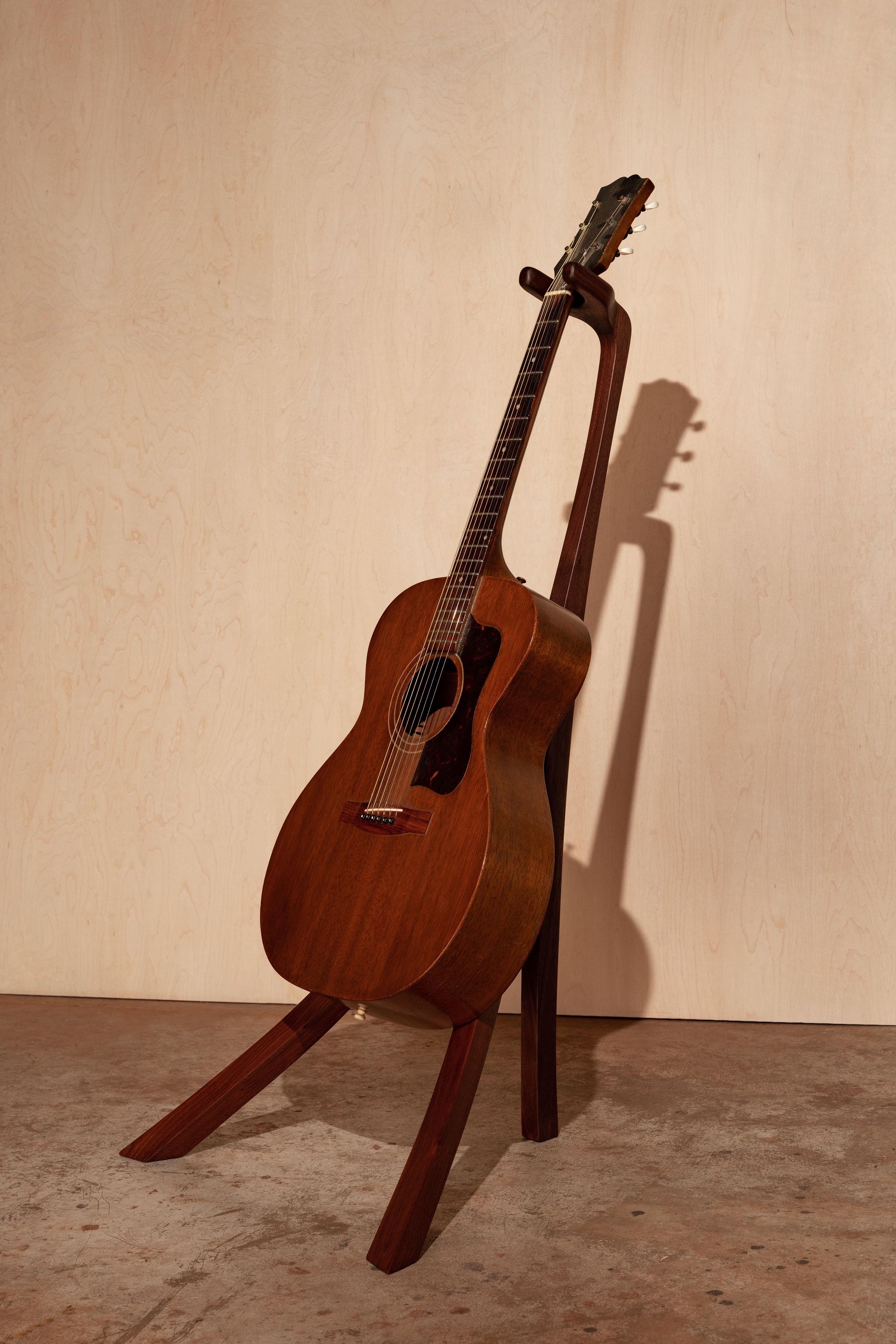 This is a handmade, sculptural guitar stand, built from black walnut. The neck opening is 2”; accommodating most electric and acoustic guitars. Custom makes are always welcome, so let me know if you’d like something different, but this one is ready