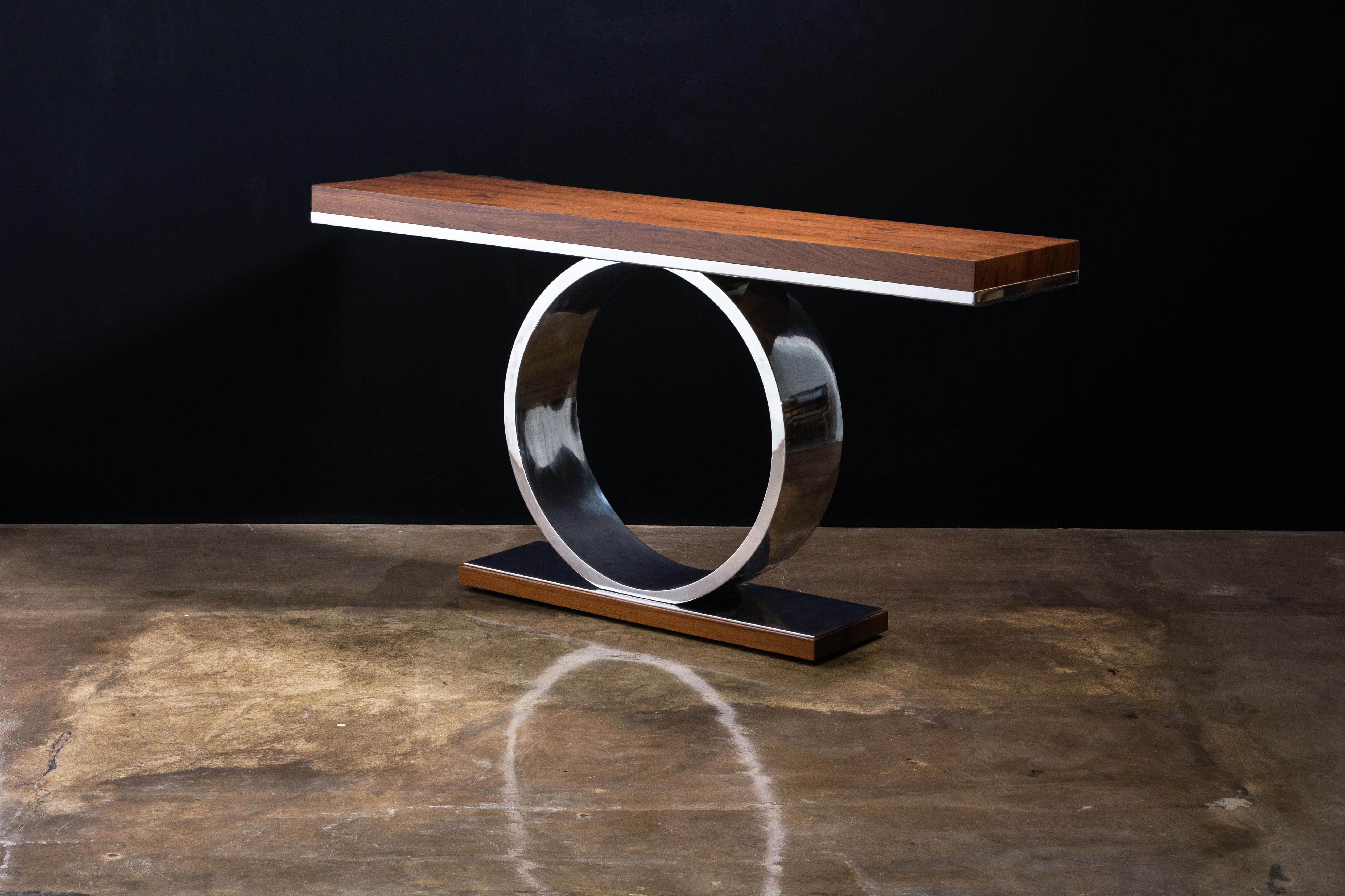 Donte Modern Sculptural Polished Steel and Wood Console Table from Costantini

The Donte console table features a ring-shaped metal base, shown here in polished steel, supporting a high gloss wood top. Available in any species, size, or finish.