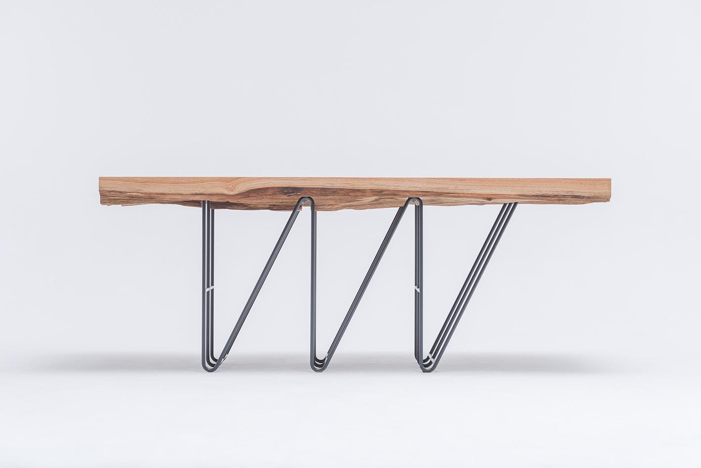 MASIV Oak Table
A sculptural presence built on contrast and craft.

The MASIV Oak Table is a bold composition of opposites: a solid, expressive oak top floating above a slender, graphic steel base. Inspired by architectural forms—particularly the