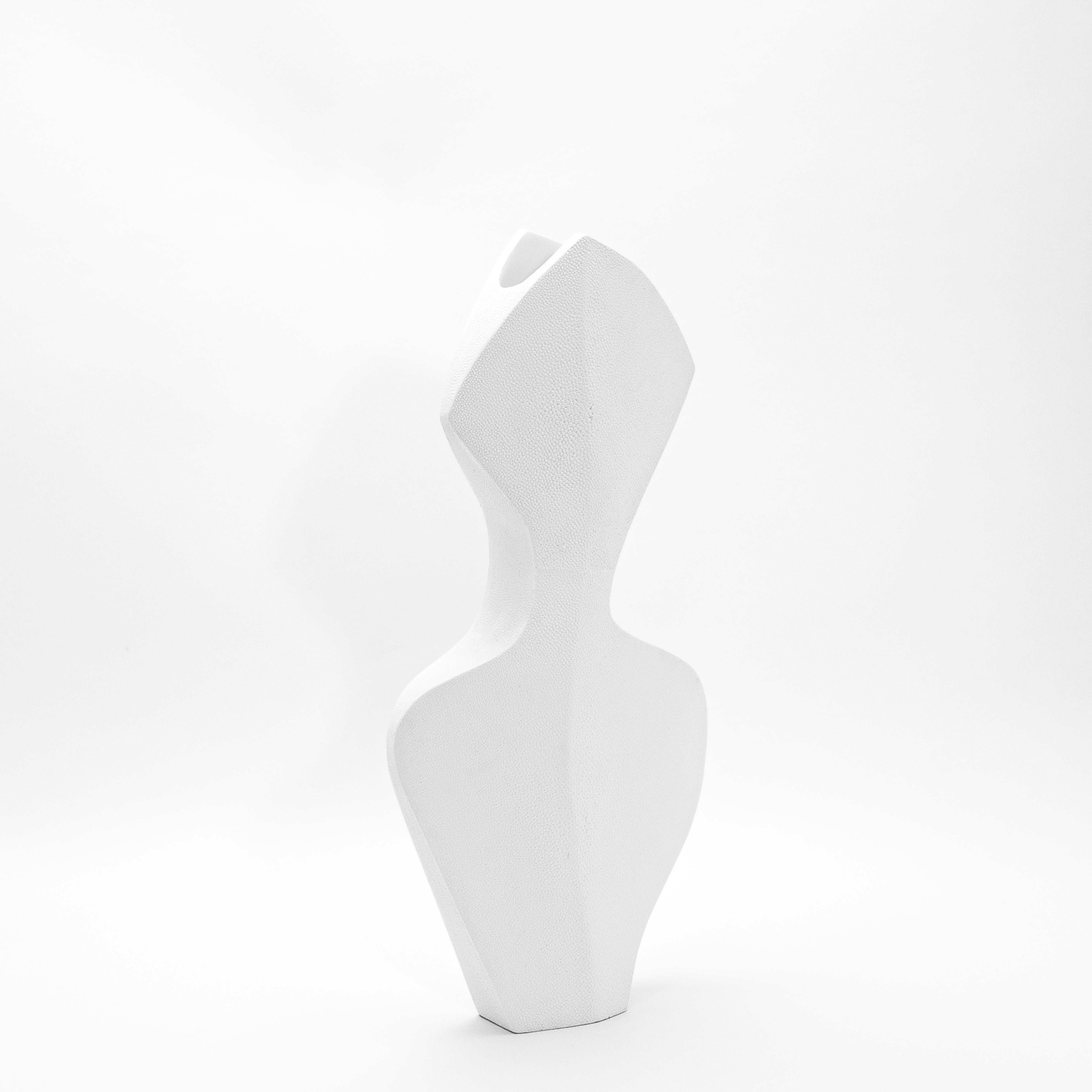 Il vaso La Dame di R&Y Augousti è una splendida incarnazione di eleganza e maestria artigianale. Realizzata in lussuoso zigrino bianco, la sua superficie tattile irradia raffinatezza, creando un contrasto sorprendente con la sua forma minimalista.