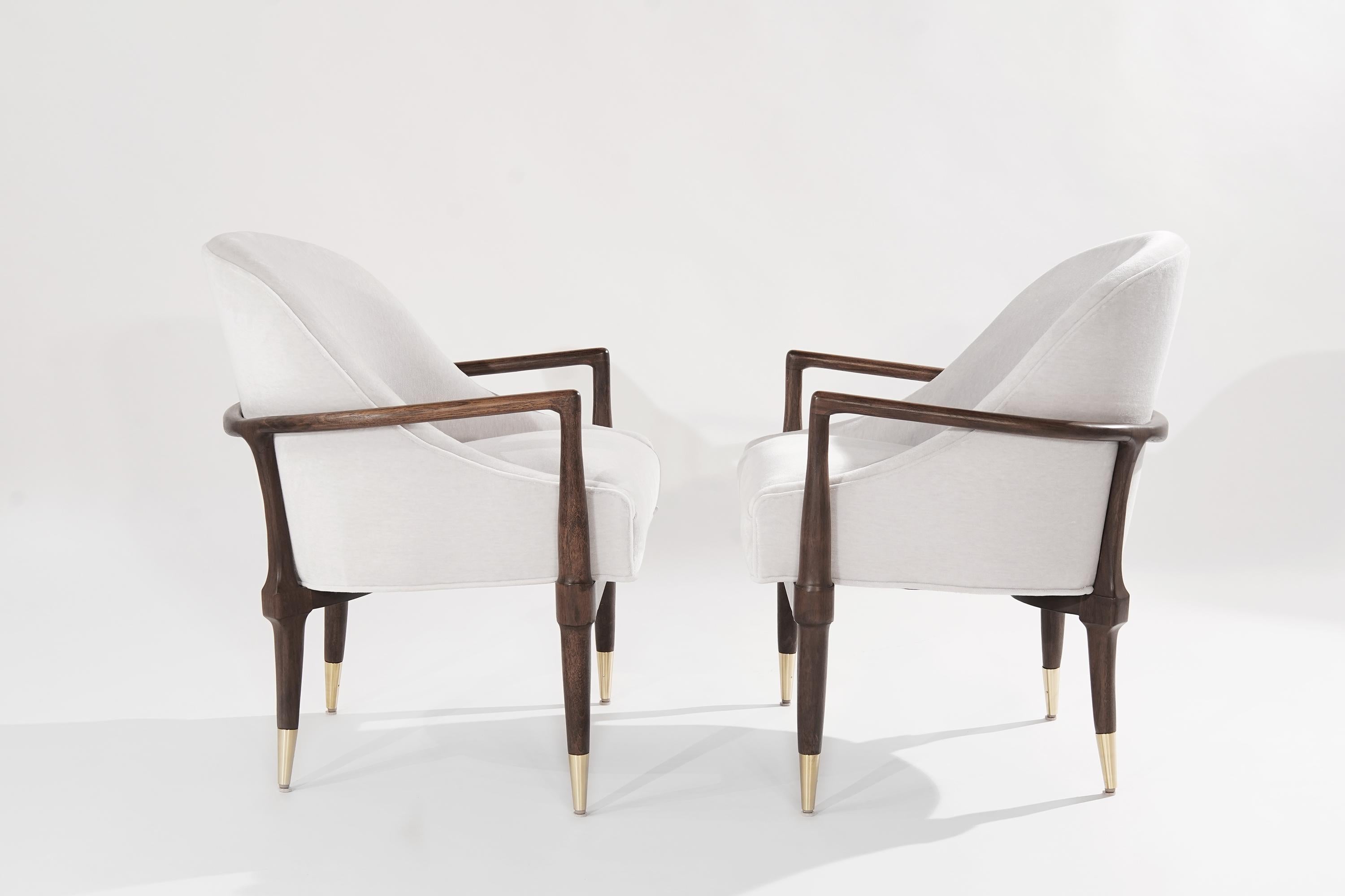Pair of lounge chairs in the style of T.H. Robsjohn-Gibbings for Widdicomb. Featuring completely restored sculptural walnut frames and hand-polished brass sabots. 

Newly upholstered in off-white velvet by Holly Hunt.

Other designers working in
