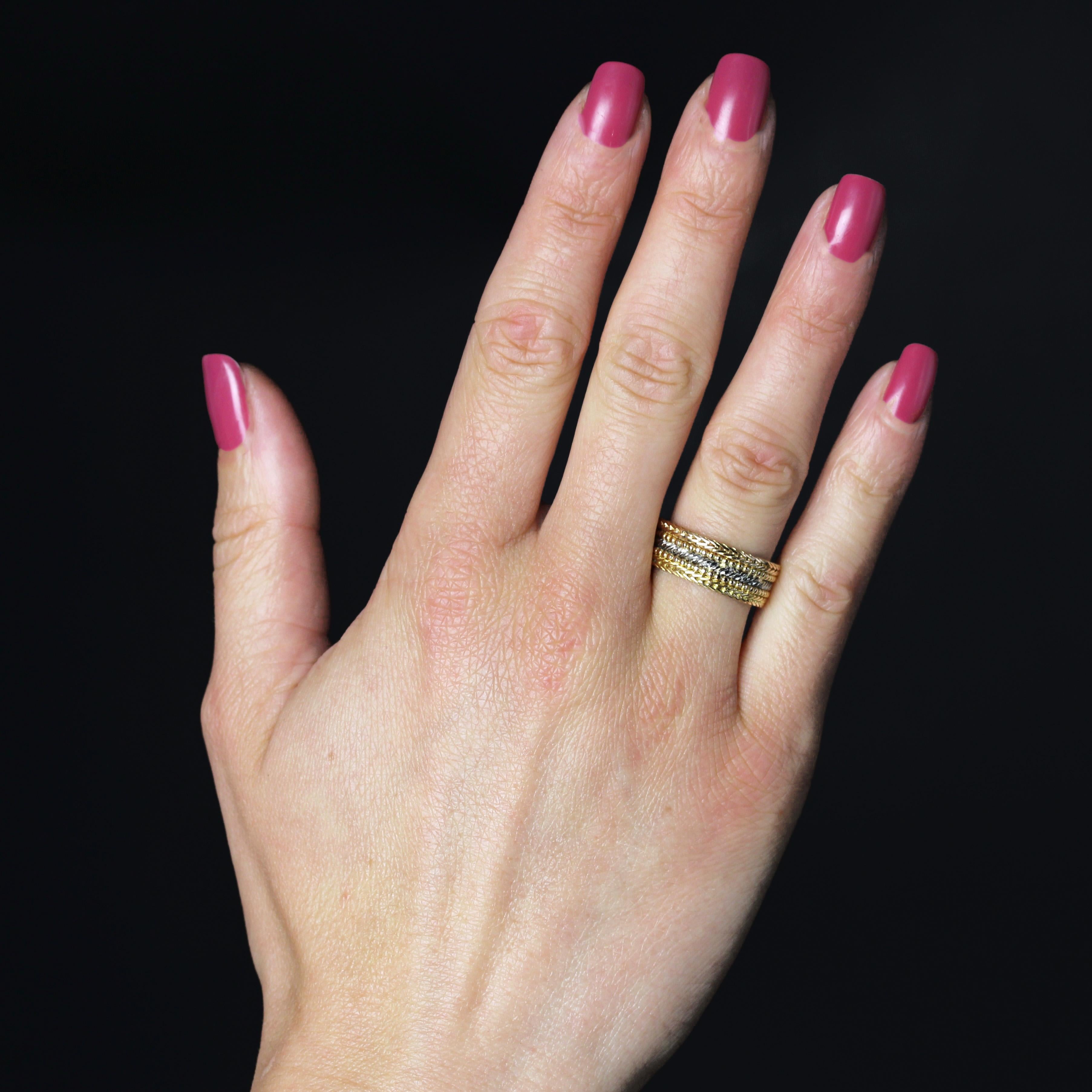 Ring in 18 karat rose and white gold.
A wide wedding band in 2 colors of gold, it is made up of 5 rings, 2 of which are pearled in rose gold, 2 of which are formed from a braid of gold wires and the one in between is chased in white gold.
Height :