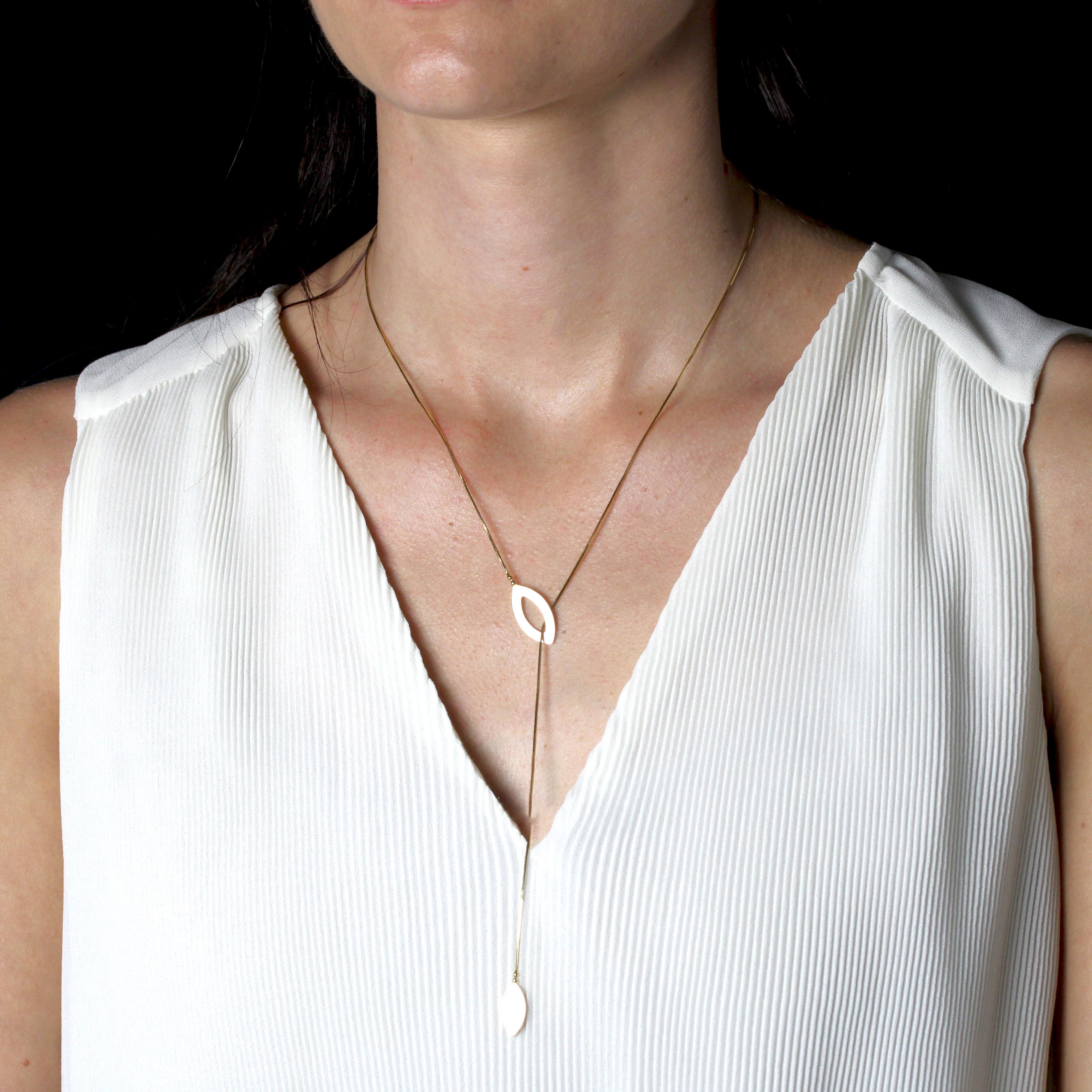 Halskette aus 18 Karat Gelbgold, Adlerkopfpunze.
Diese moderne Halskette besteht aus einer feinen Schlangenkette, an deren Enden jeweils ein durchbrochenes Schiffchenmotiv und ein massives Schiffchenmotiv angebracht sind. Letztere ist in das