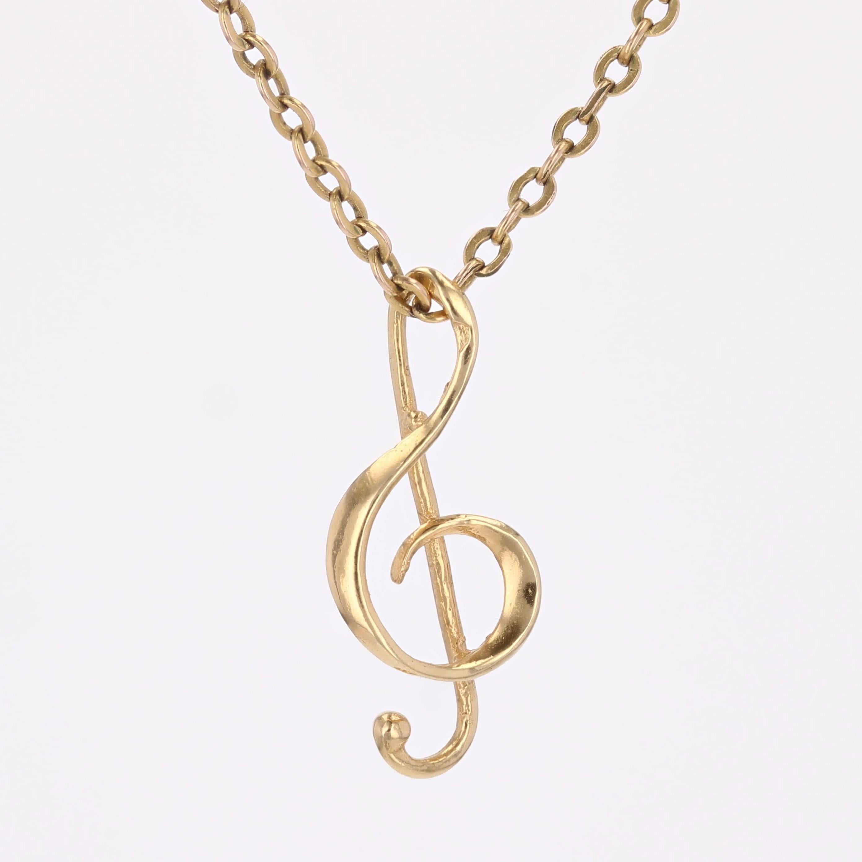 Pendentif en or jaune 18 carats, poinçon tête d'aigle.
Ce pendentif en or représente une clé de sol. La chaîne est enfilée dans la boucle supérieure.
Pendentif vendu seul, sans la chaîne de présentation.
Hauteur : 2,1 cm environ, largeur : 9 mm