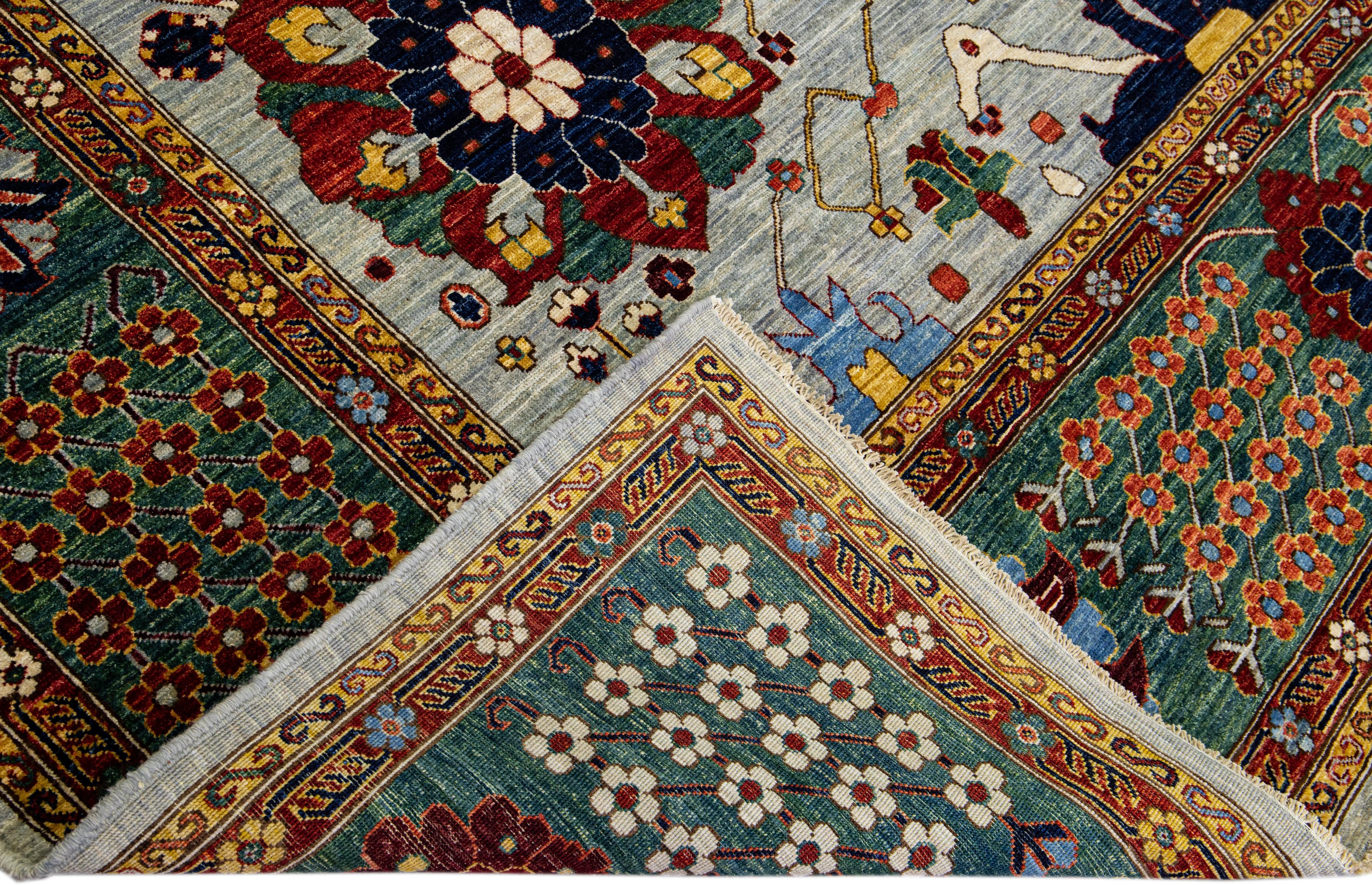 Magnifique tapis ancien en laine nouée à la main de style Serapi avec un champ gris clair. Cette pièce a un cadre vert et un magnifique motif floral sur toute sa surface avec des accents multicolores.

Ce tapis mesure 9' x 12'

Nos tapis sont