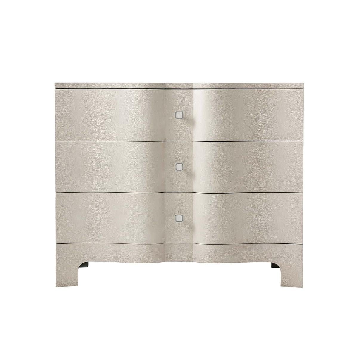 Modern Serpentine leather wrapped nightstand with a shagreen embossed leather in our light overcast finish, with polished nickel hardware and raised on bracket feet.

A wonderful modern interpretation of a Rococo Chippendale design from the 18th