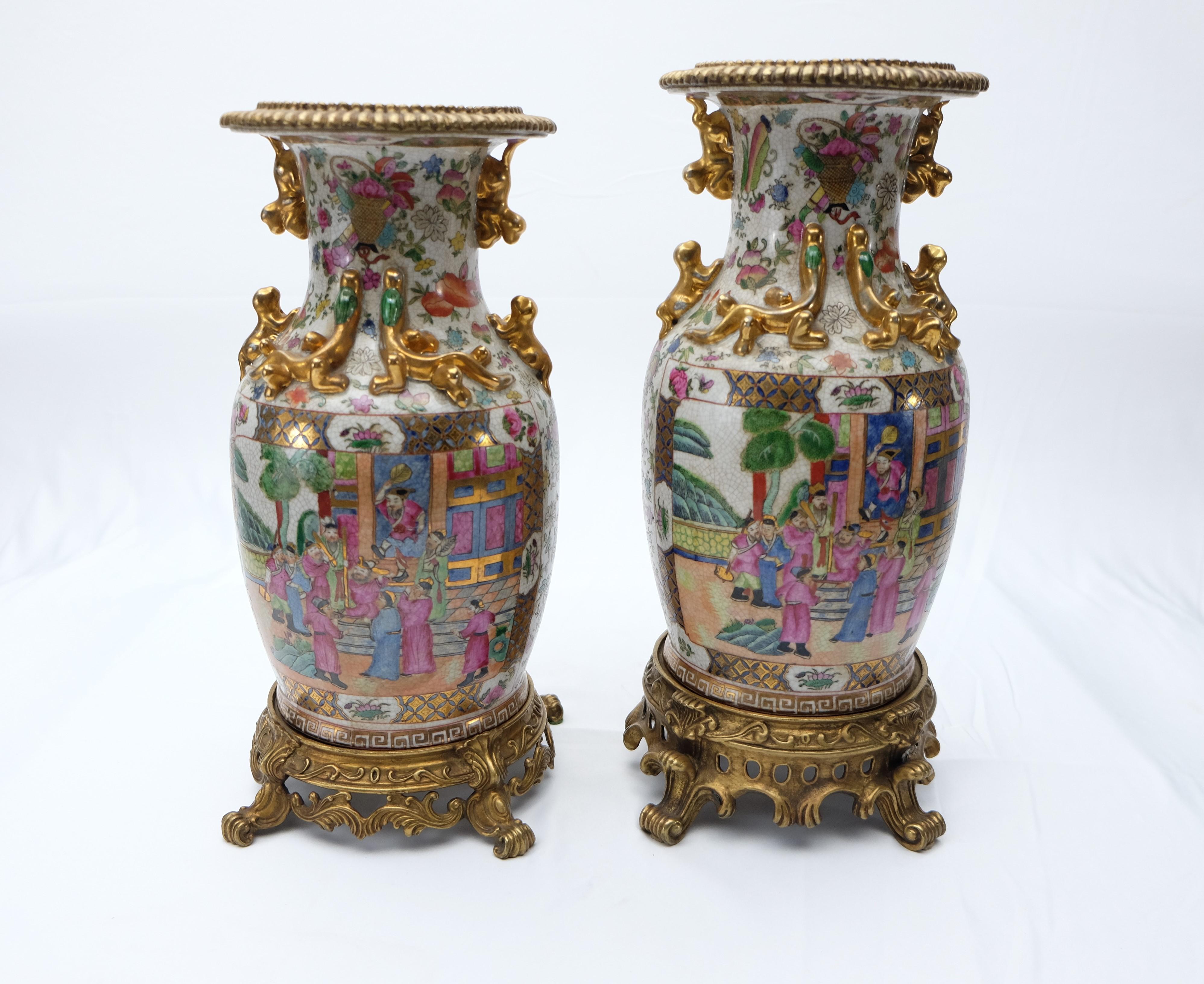 Modern set of two Famille rose urns on bronze stands offered for sale are two modern Famille rose porcelain Chinese vases presented upon ornate bronze stands. Meaning 