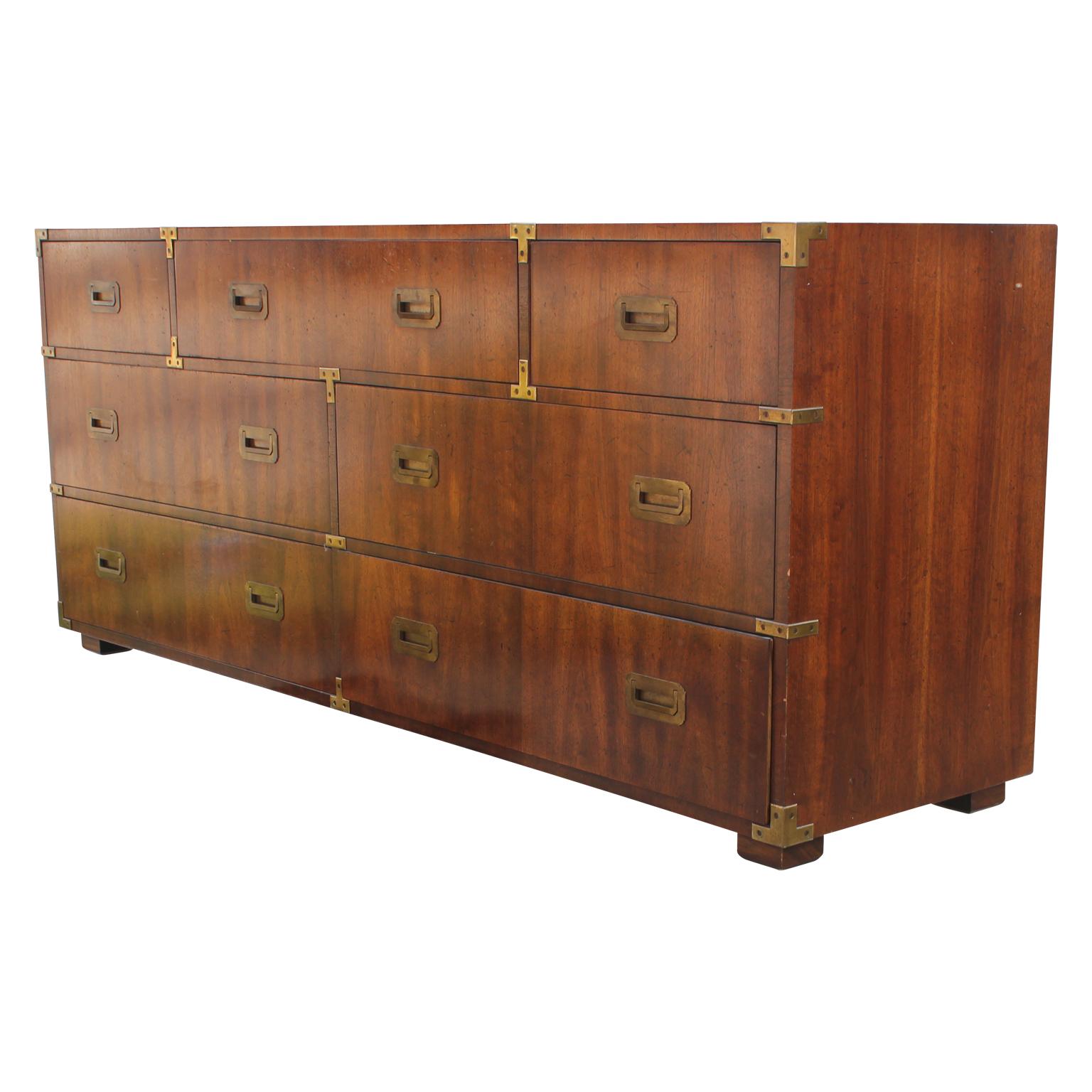 Gorgeous modern Campaign style seven-drawer dresser with brass accents by Henredon. Made from a lovely walnut.