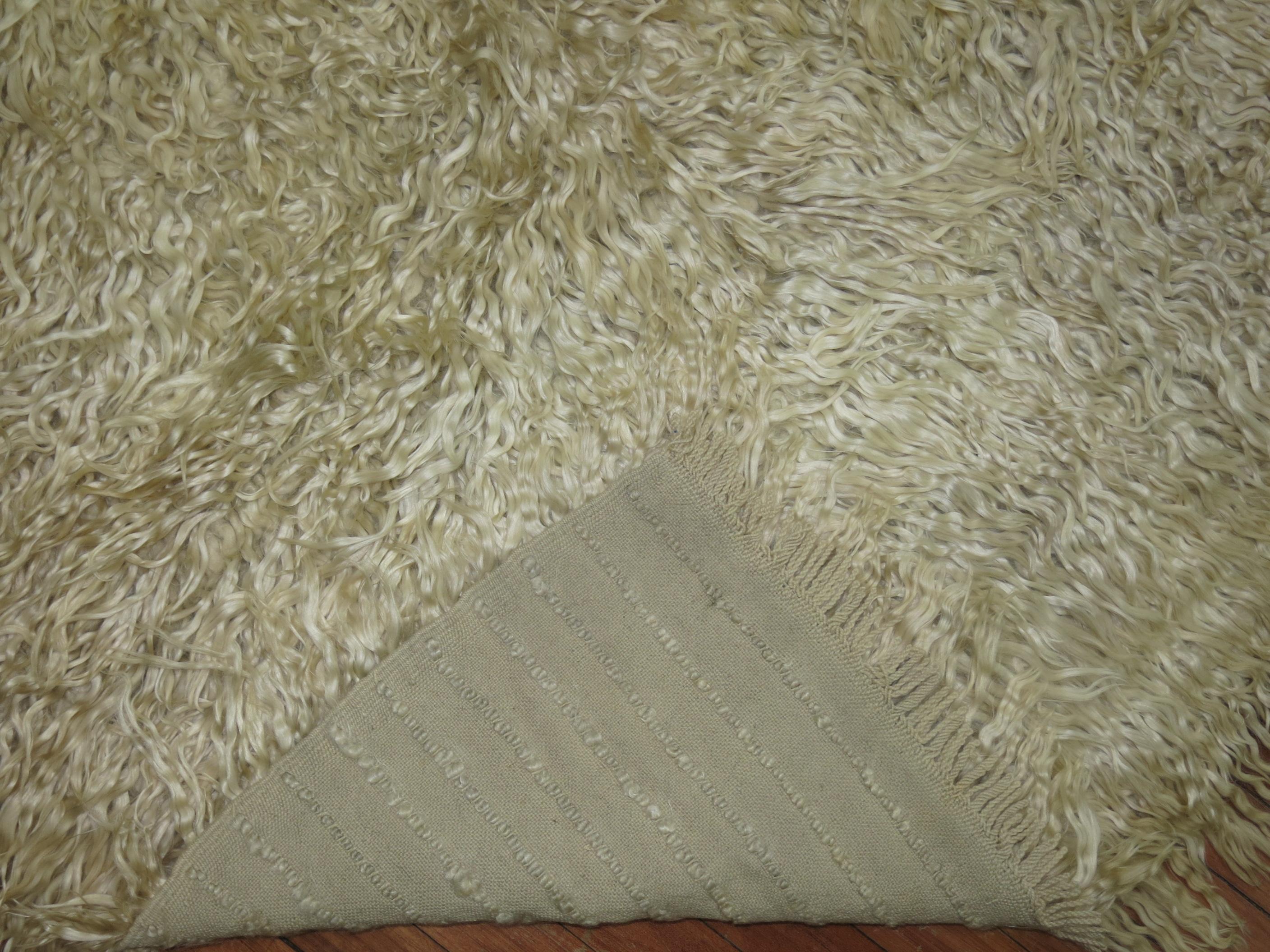 Monotone handwoven cream colored Turkish Shag rug.
