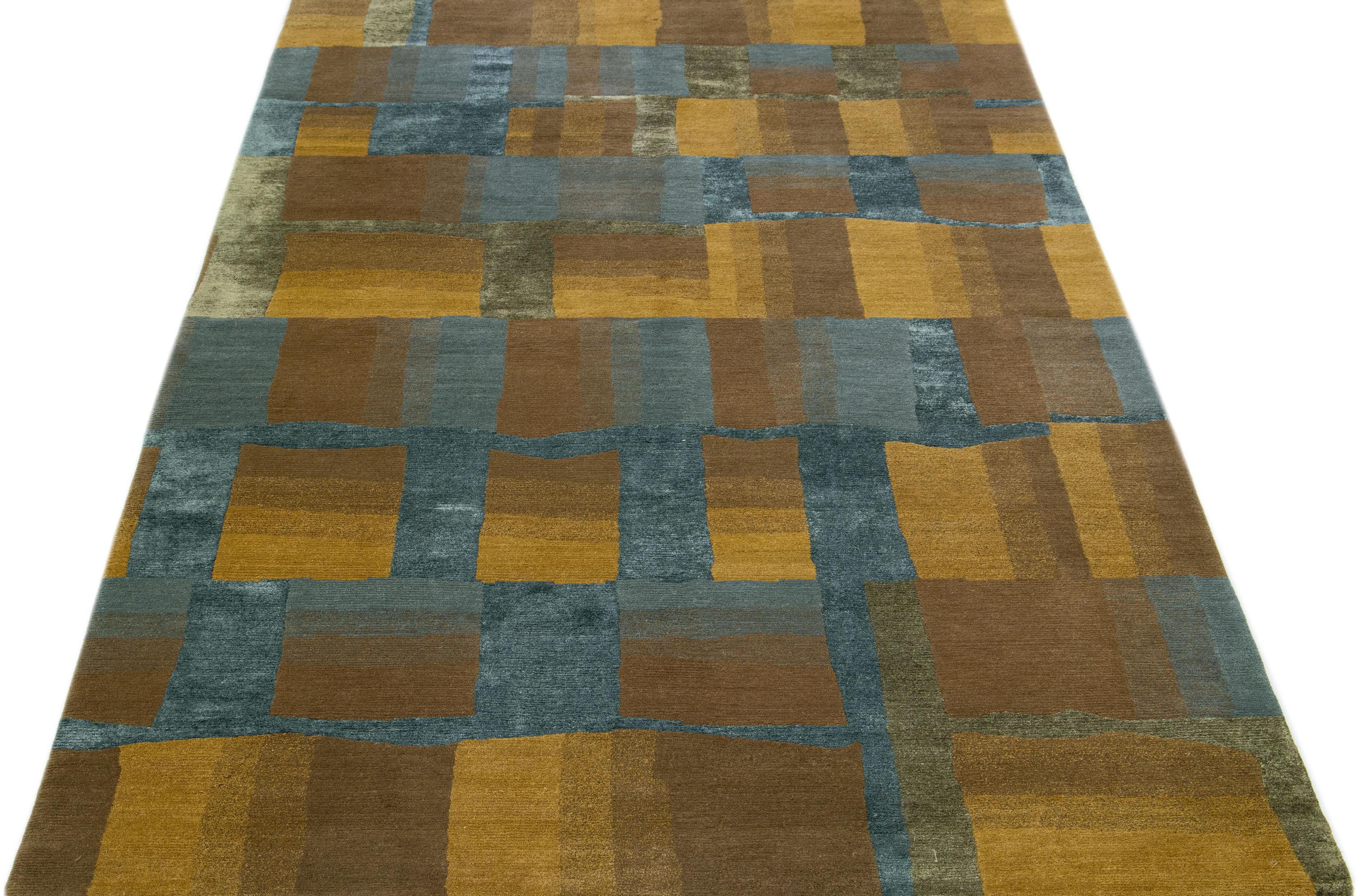 This contemporary Tibetan rug is expertly crafted by hand using wool and silk and boasts a striking brown and yellow color field. Adding to its charm is an all-over abstract geometric pattern in blue.

This rug measures 6' x 9'.