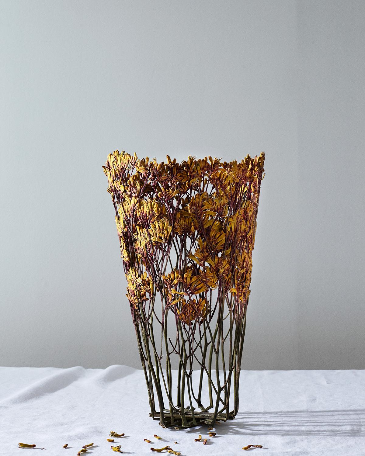 Vase artisanal créé avec des fleurs séchées au soleil, acquises localement au marché de Londres, ville de son auteur. Les fleurs sélectionnées sont donc toujours uniques : après un processus de séchage de deux mois, les fleurs sont tissées ensemble