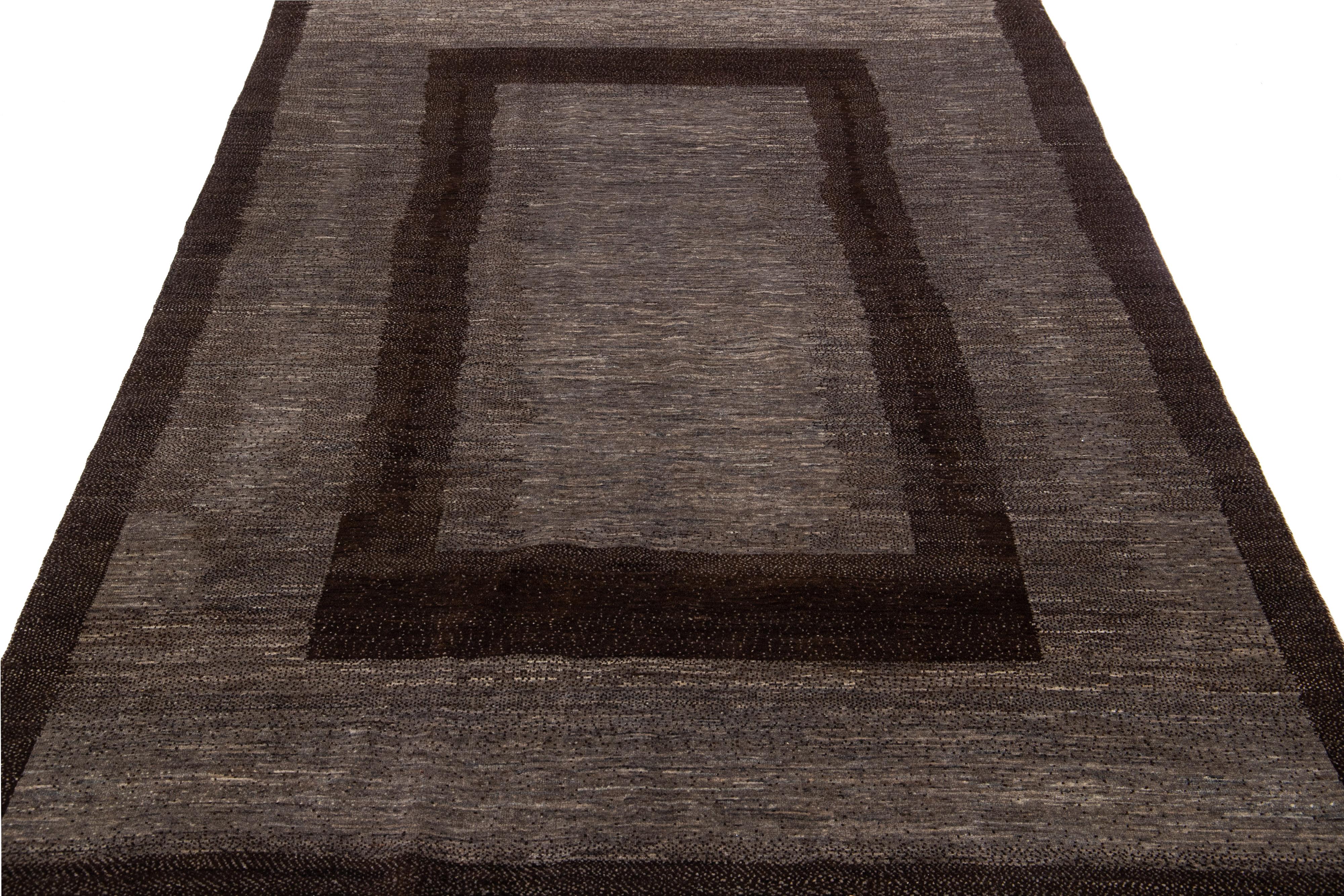 Beautiful modern Gabbeh-style hand-woven wool rug with a gray and brown color field in a gorgeous geometric design.

This rug measures: 5'6