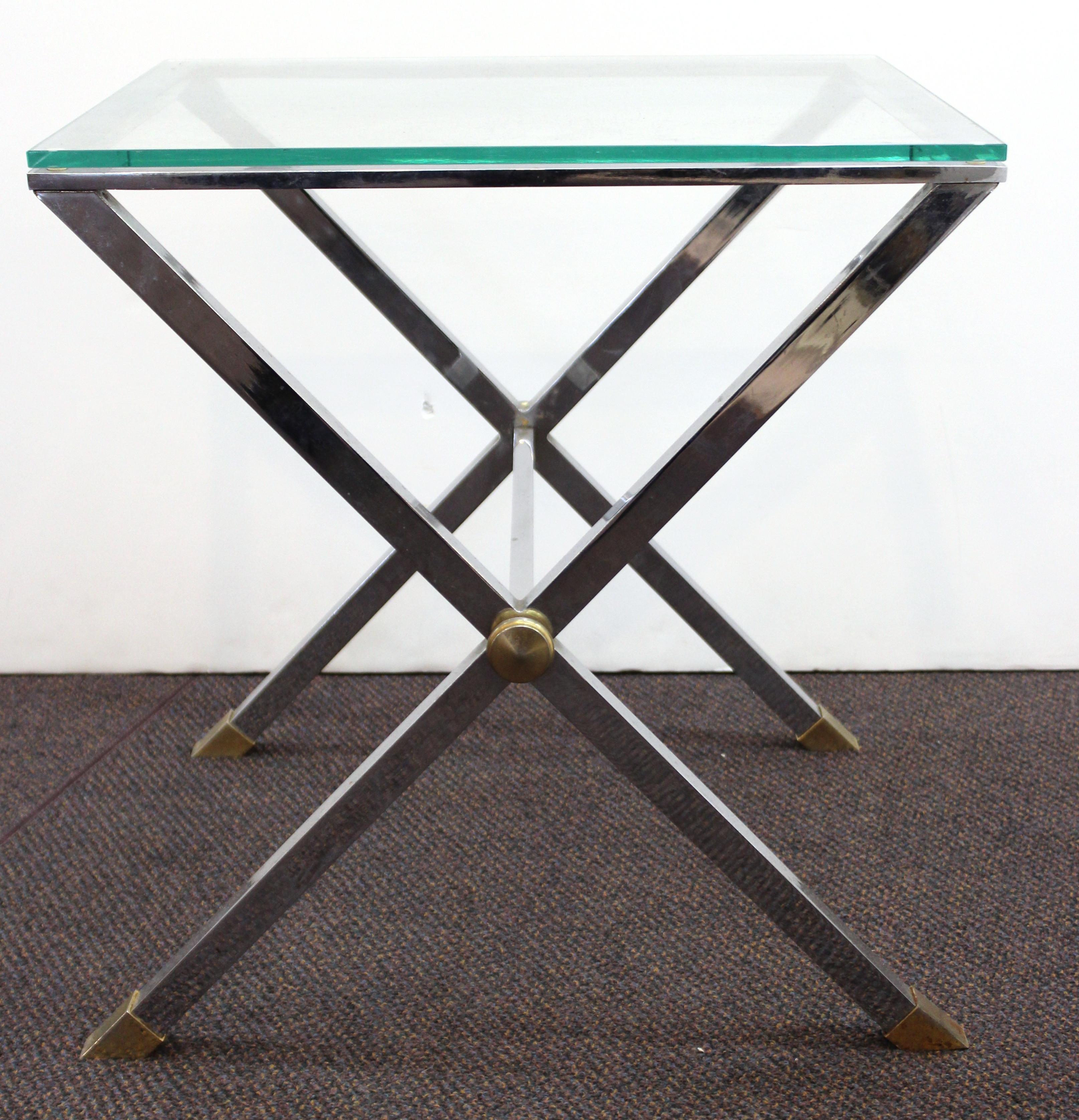 Modern side table with a chromed metal X-shaped base and a square clear glass top, in the style of Karl Springer. The piece is in great vintage condition with age-appropriate wear and use. 

Dealer: S138XX