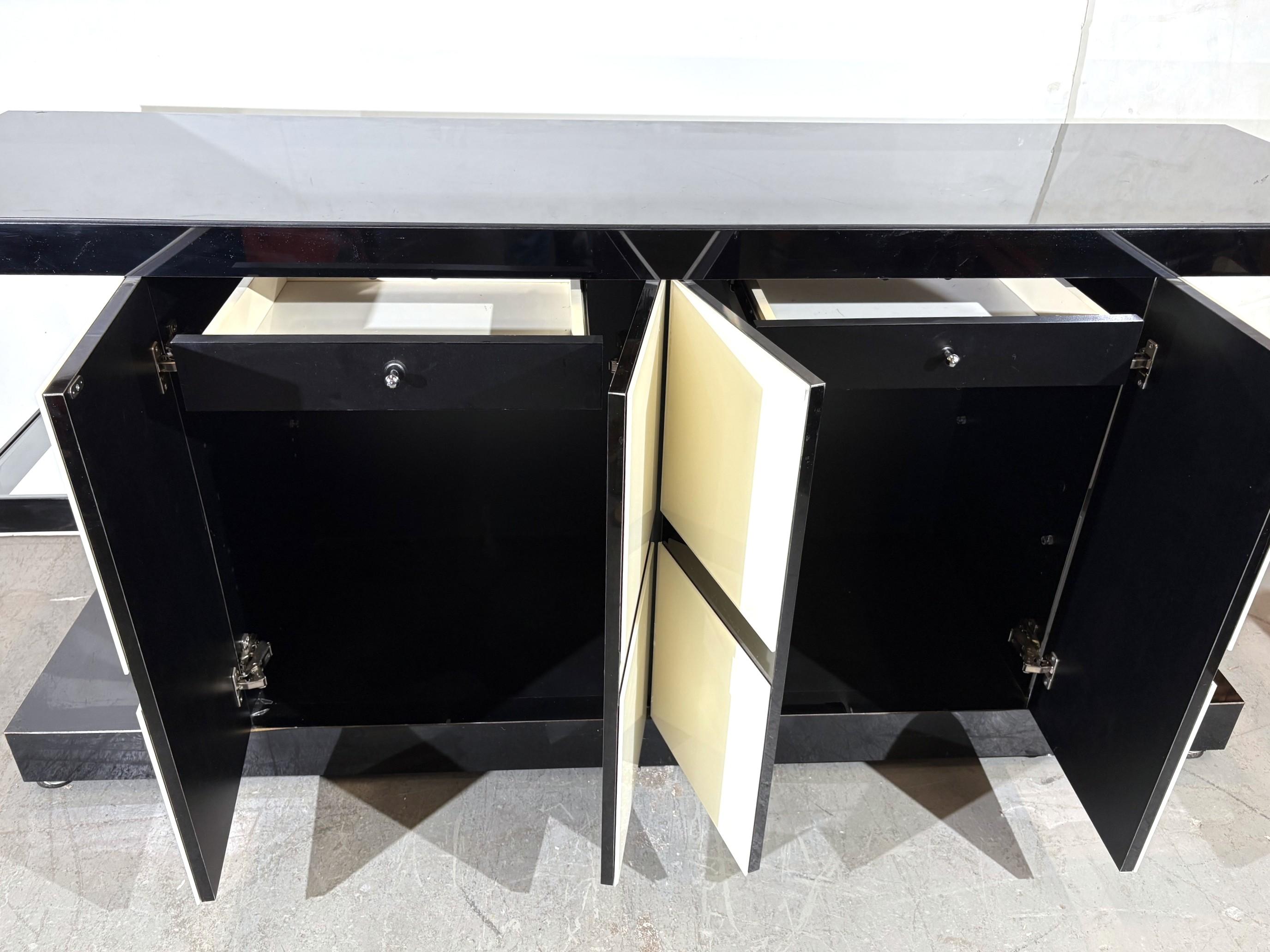 La credenza ha il piano e le ante in vetro e il vetro laterale può essere rimosso con una luce a binario.
Ci sono quattro ante e due cassetti.