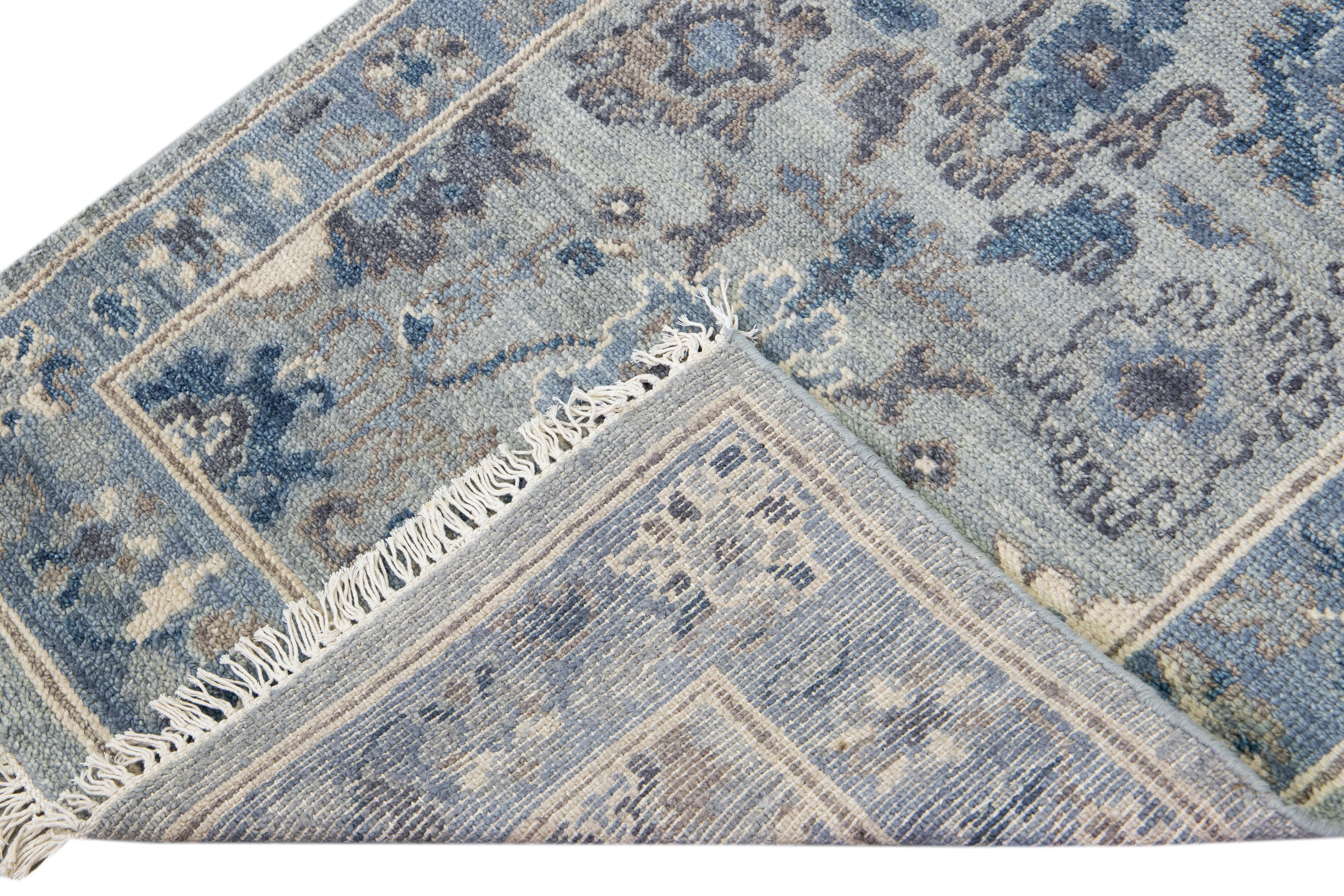 Beautiful modern Oushak hand-knotted wool runner with a silver-gray field. This Oushak rug has a blue designed frame with blue and beige accents all over a gorgeous floral design.

This rug measures 3'1