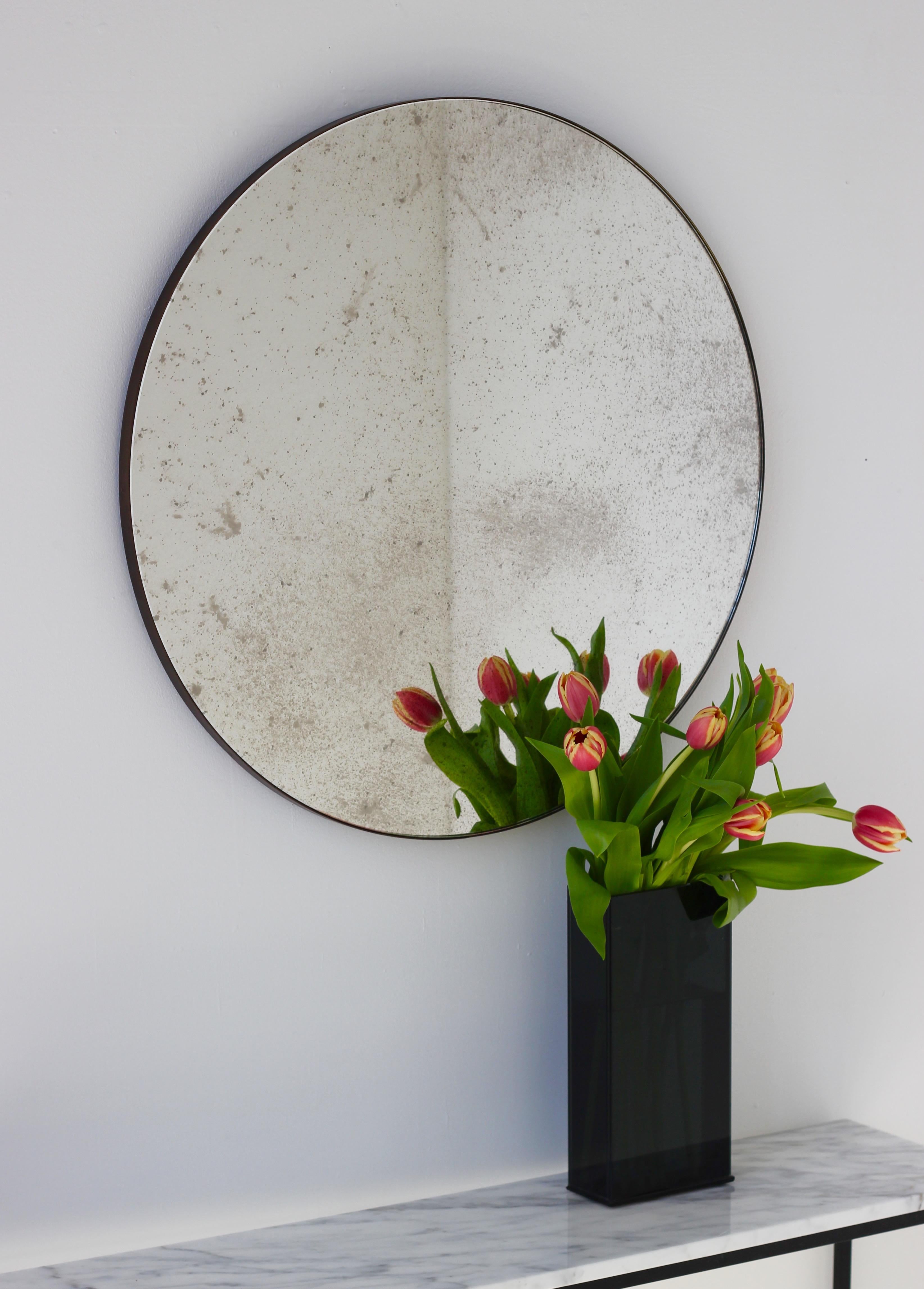 Delightful antiqued Orbis™ round mirror with a minimalist bronze patina brass frame. Designed and handcrafted in London, UK.

Medium, large and extra-large mirrors (60, 80 and 100cm) are fitted with an ingenious French cleat (split batten) system so