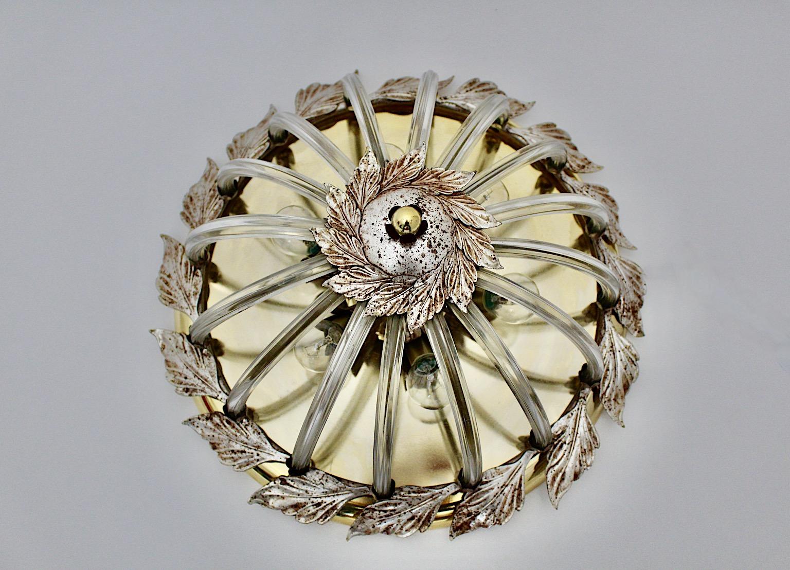 Modern vintage flush mount from silver, brass and glass round shape 1970s Italy.
The beautiful lighting or flush mount from silver plated and brass plated metal shows leaves as decor as well as 16 slightly curved clear glass rods.
It looks like